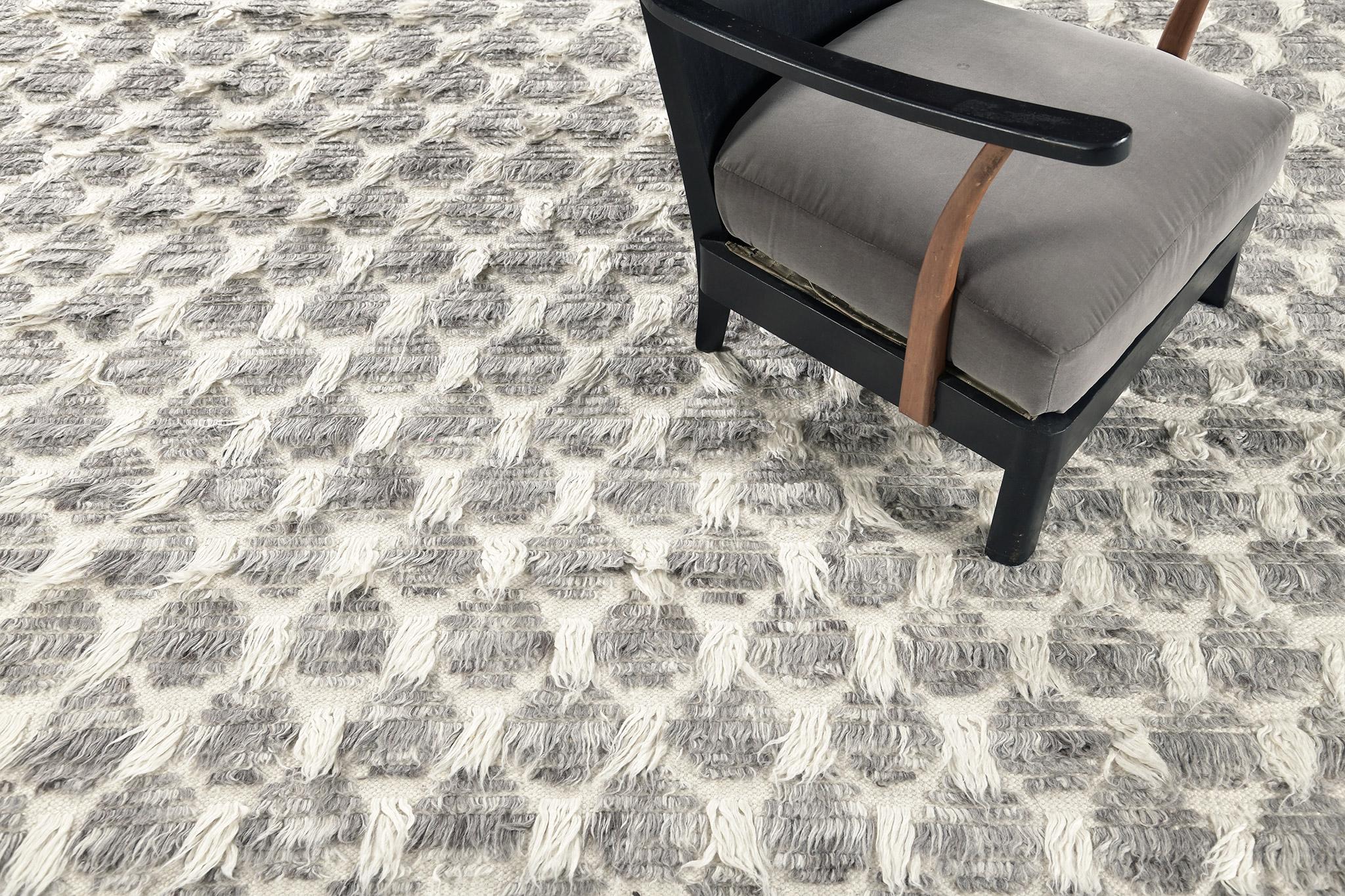 In the Nami rug, varied pile heights and flatweave design elements are configured in a petal lattice motif of dappled gray with ivory lineation.

An extension of Mehraban’s popular Amihan design, the Sahara Collection delves further with grid-riffs