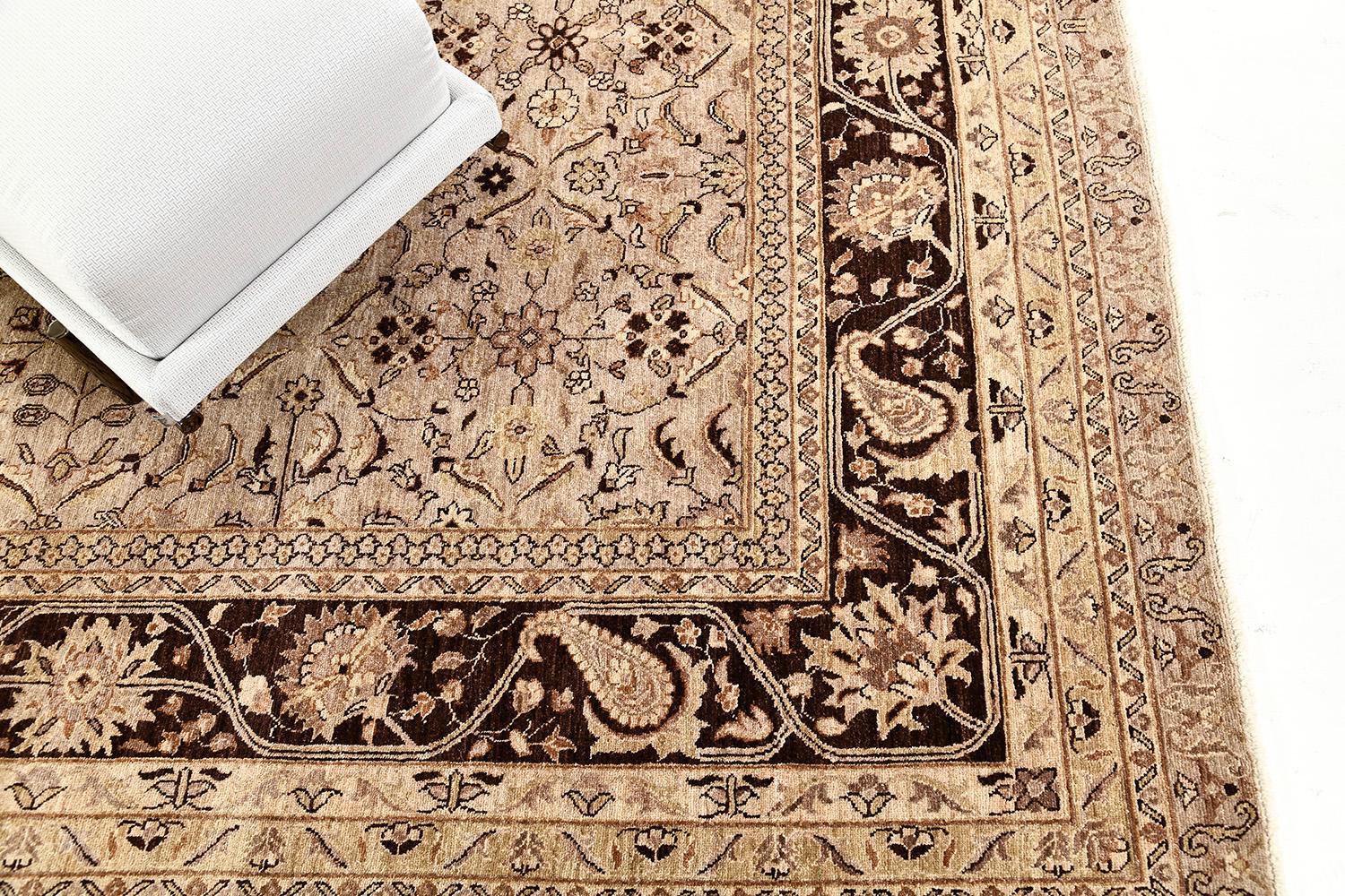 An incredible Amritsar revival rug with various forms that complement with each other harmoniously. Featuring the majestic neutral colour scheme of tan, taupe and umber brown, this magnificent rug comprises all-over details of serrated leaves,