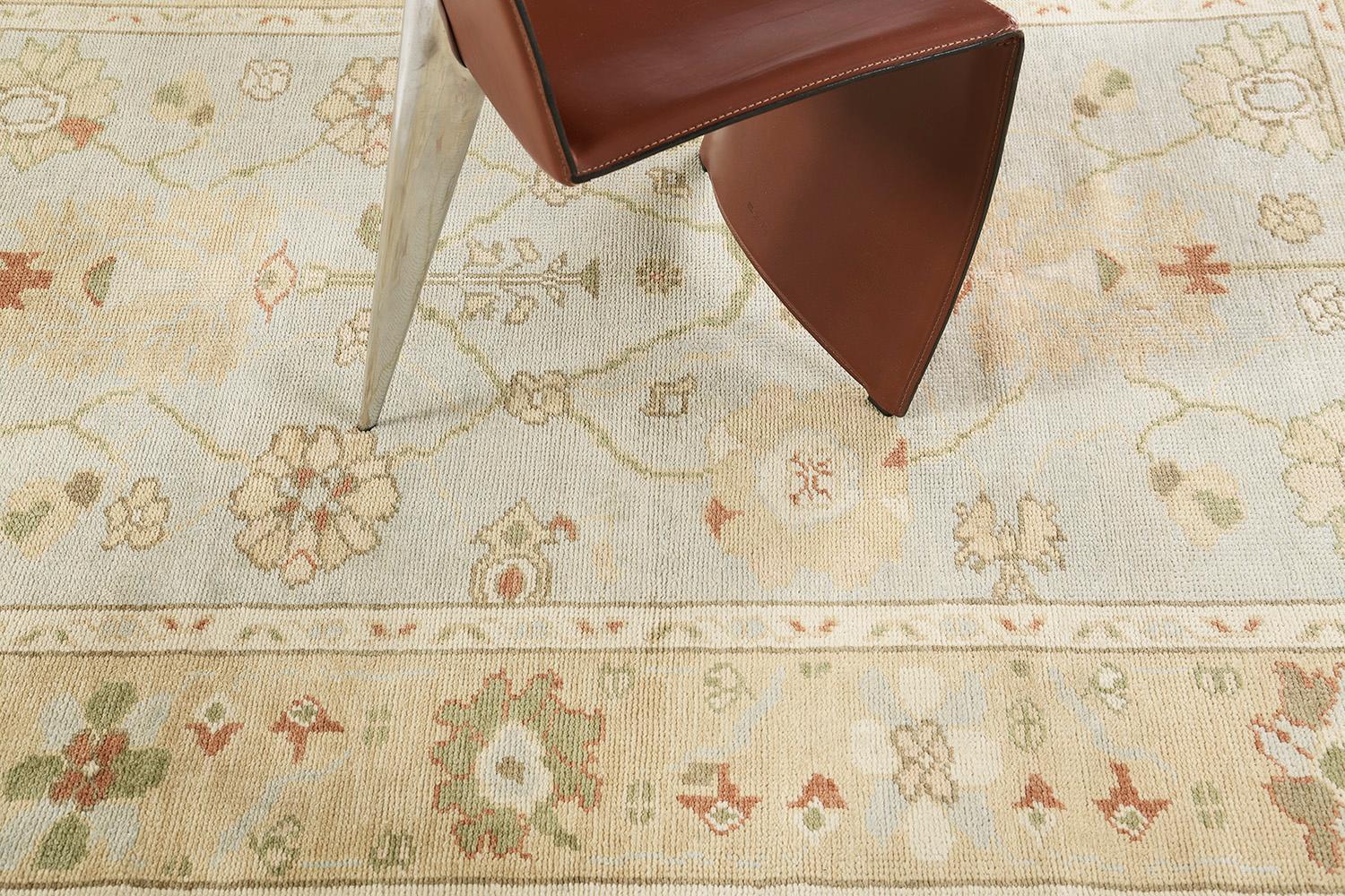 A poised Oushak revival rug that is a magnificent impression of sophistication and soft beauty. Distinctive palmettes, graceful peonies and florid patterns are showcasing refined elegance in the remarkable shades of khaki, sand, ivory, sky blue and