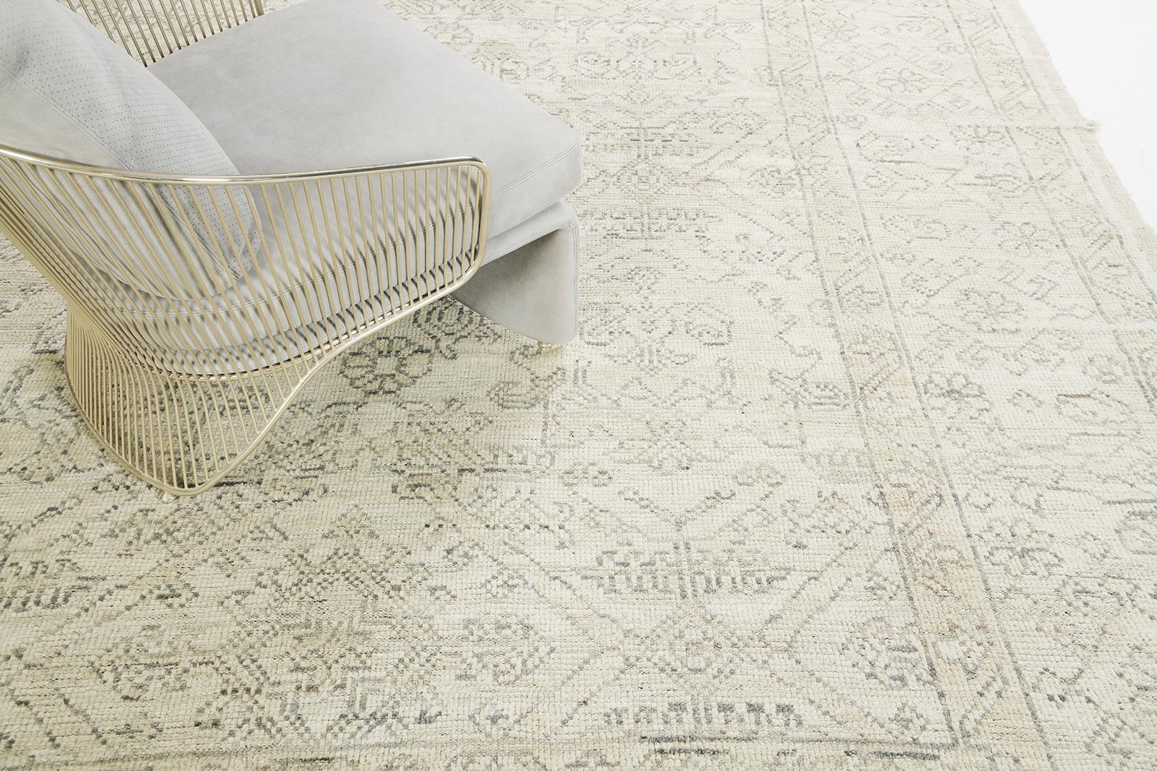 Una sobrecogedora alfombra de renacimiento Oushak en tonos apagados de almendra y carbón, estilizada con gracia con motivos Herati. Elegante y sofisticada, esta alfombra de lana hilada a mano está enmarcada por un borde complementario lleno de