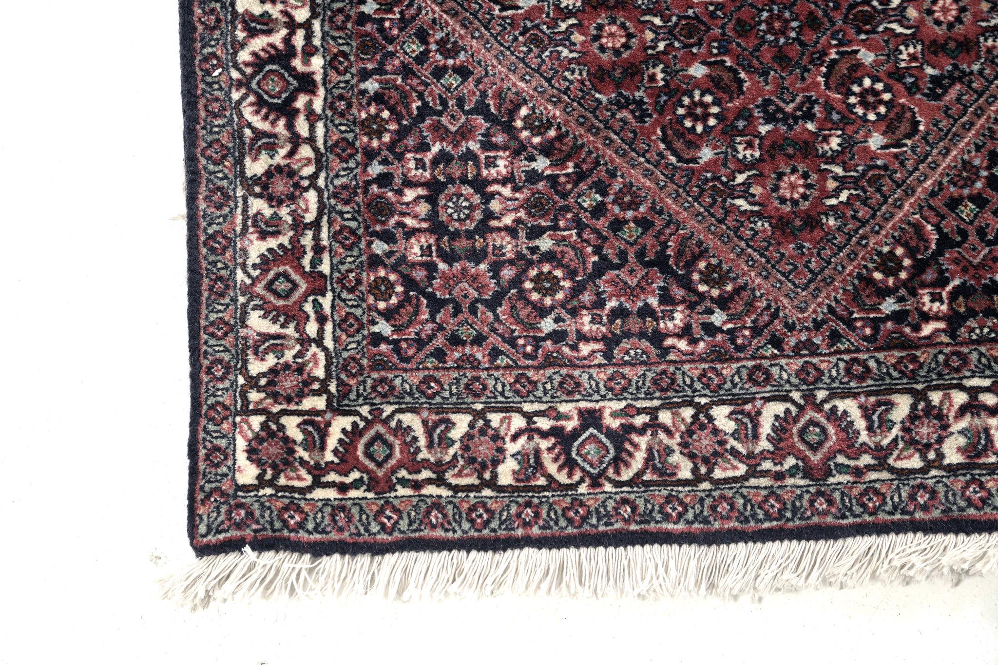 Esta tradicional alfombra persa Bidjar presenta los más bellos tonos de rojo como su notable paleta de colores. A su impresionante estética se suman el azul claro, el crema y el negro, que resaltan y hacen que esta alfombra destaque. El núcleo de la