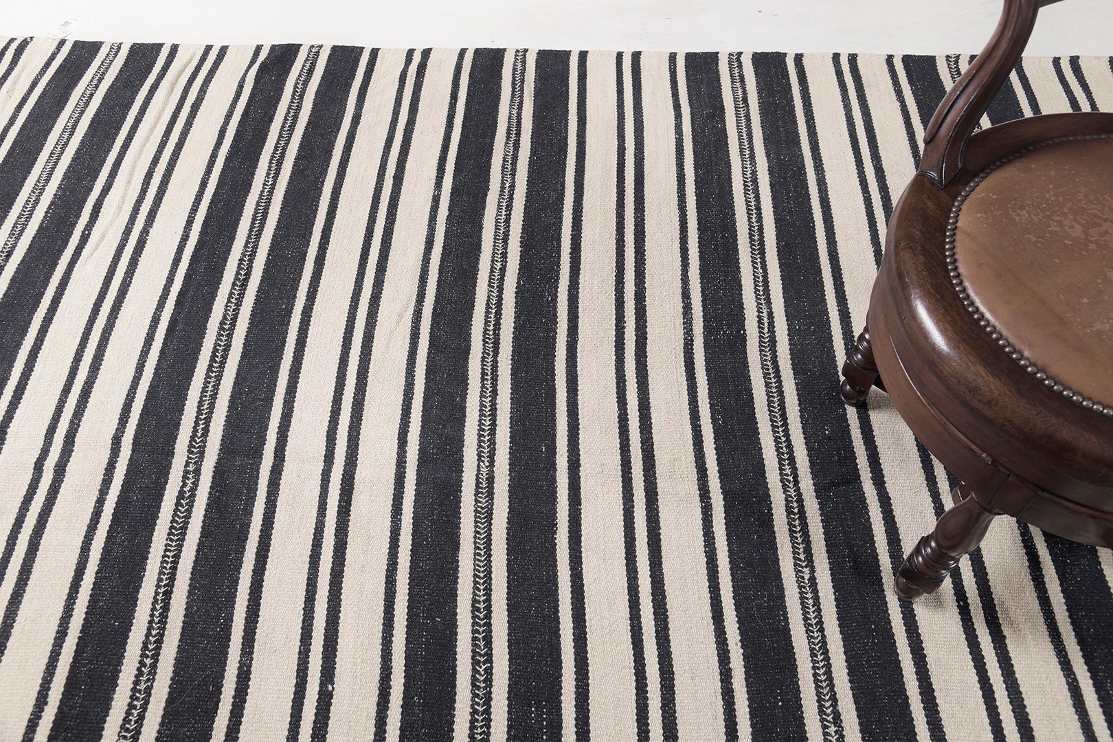 Dieser persische Jejim-Kilim ist flach gewebt und hat ein vielseitiges Muster aus schwarzen und cremefarbenen Streifen in verschiedenen Breiten. Er eignet sich perfekt für moderne, zeitgenössische Innenräume. Die grafischen Streifen auf dem Teppich