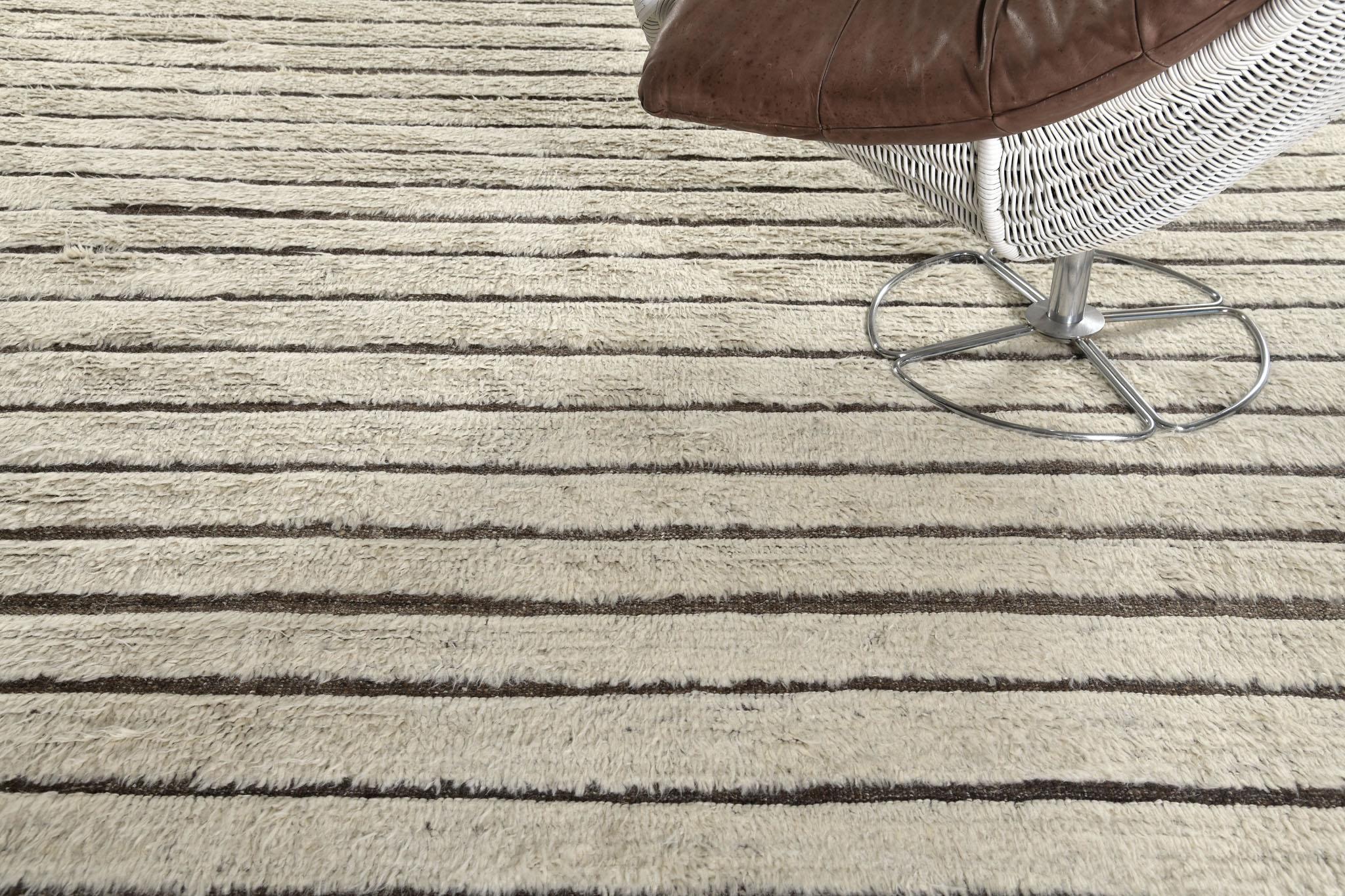 The shipca is a handwoven luxurious wool rug with timeless embossed horizontal strokes detailing. In addition to its neutral-toned flatweave, Shipca has a beautiful umber brown shag that brings a lustrous and exciting feel to one's space. The Haute