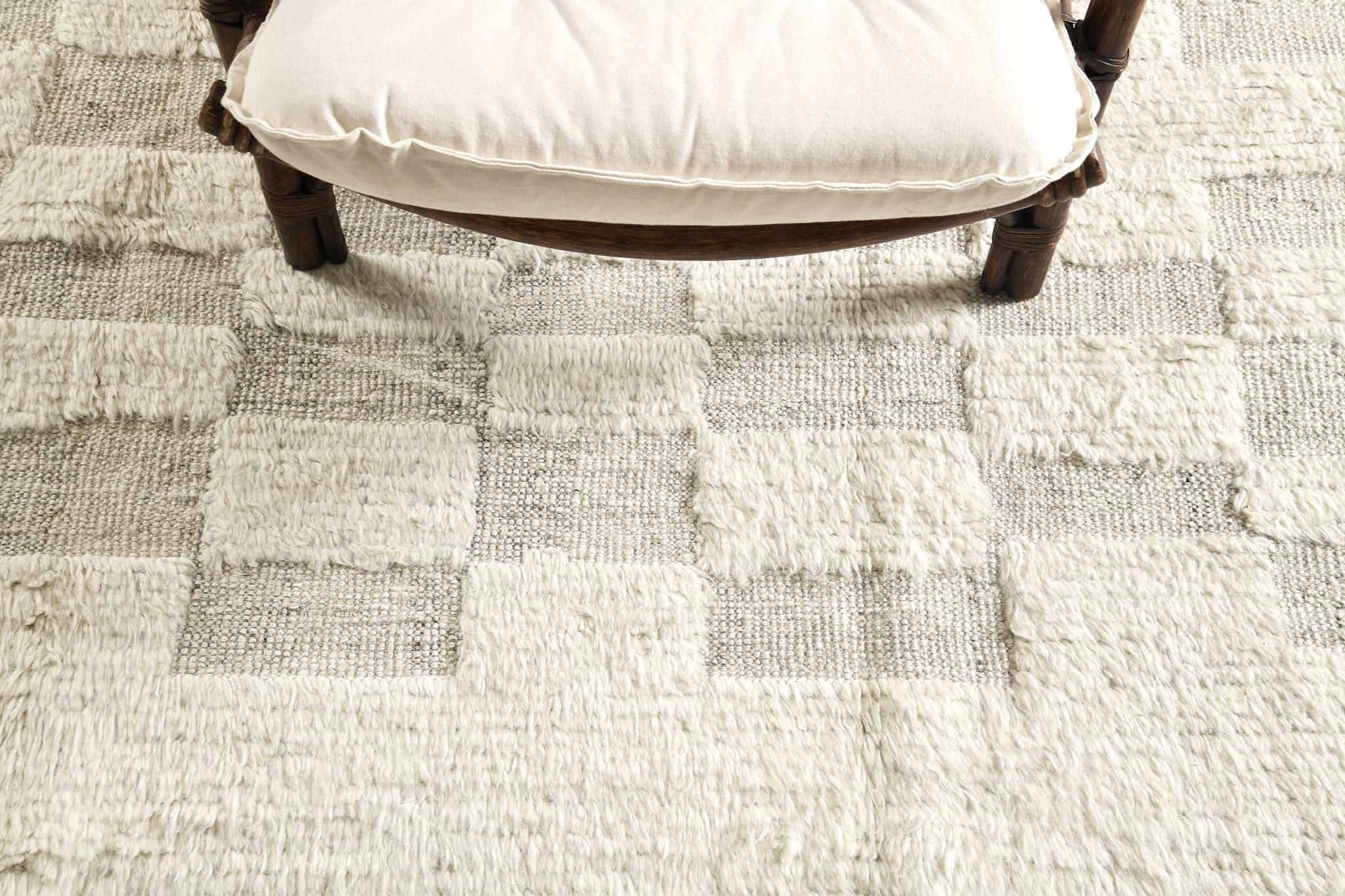 Sirocco' is a stunning hand woven ivory with embossed detailing in a checkered pattern atop a natural gray pile weave. Beautiful tassels and bordered designs add a timely and one of a kind essence for the modern design world. Haute Bohemian