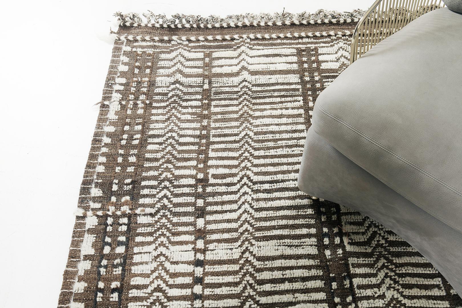 Tala’ displays a series of linear formation cohesively blending together forming a distinct character of the entirety of this magnificent rug. Rendered in chocolate brown and ivory, the texture of this mesmerizing rug brings out the warm and cozy