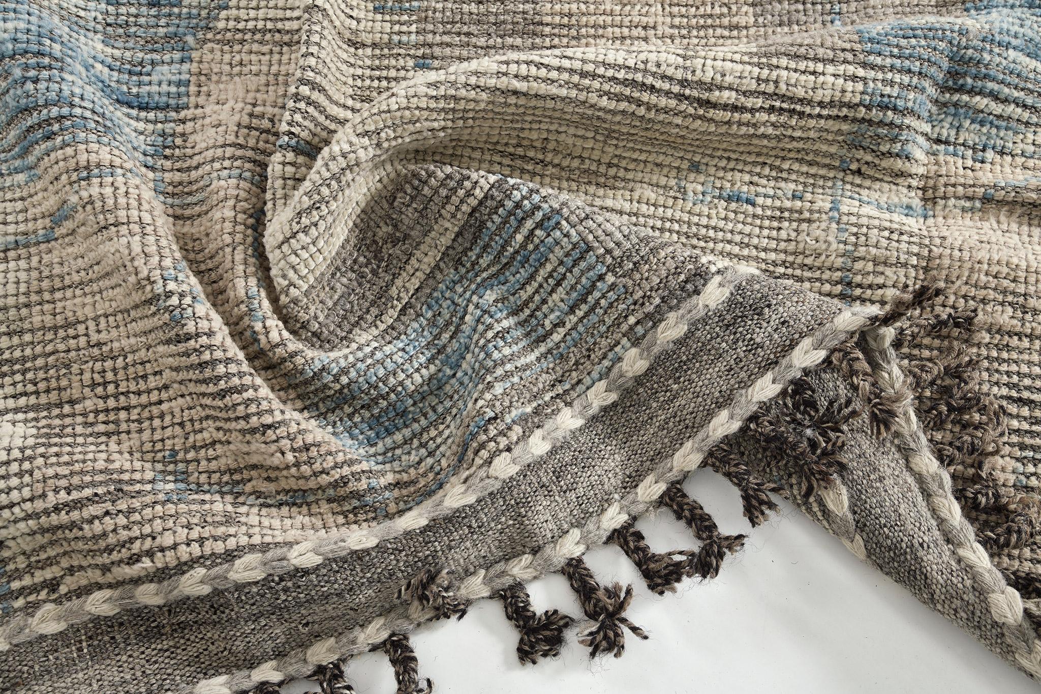 Tiznit’ reveals the ambiguous shapes formed together and emanate this masterful artsy piece. Rendered in the earthy shades of taupe, cedar and cerulean blue, this captivating rug is perfect to bring out character to any room. This collection, 'Kust'
