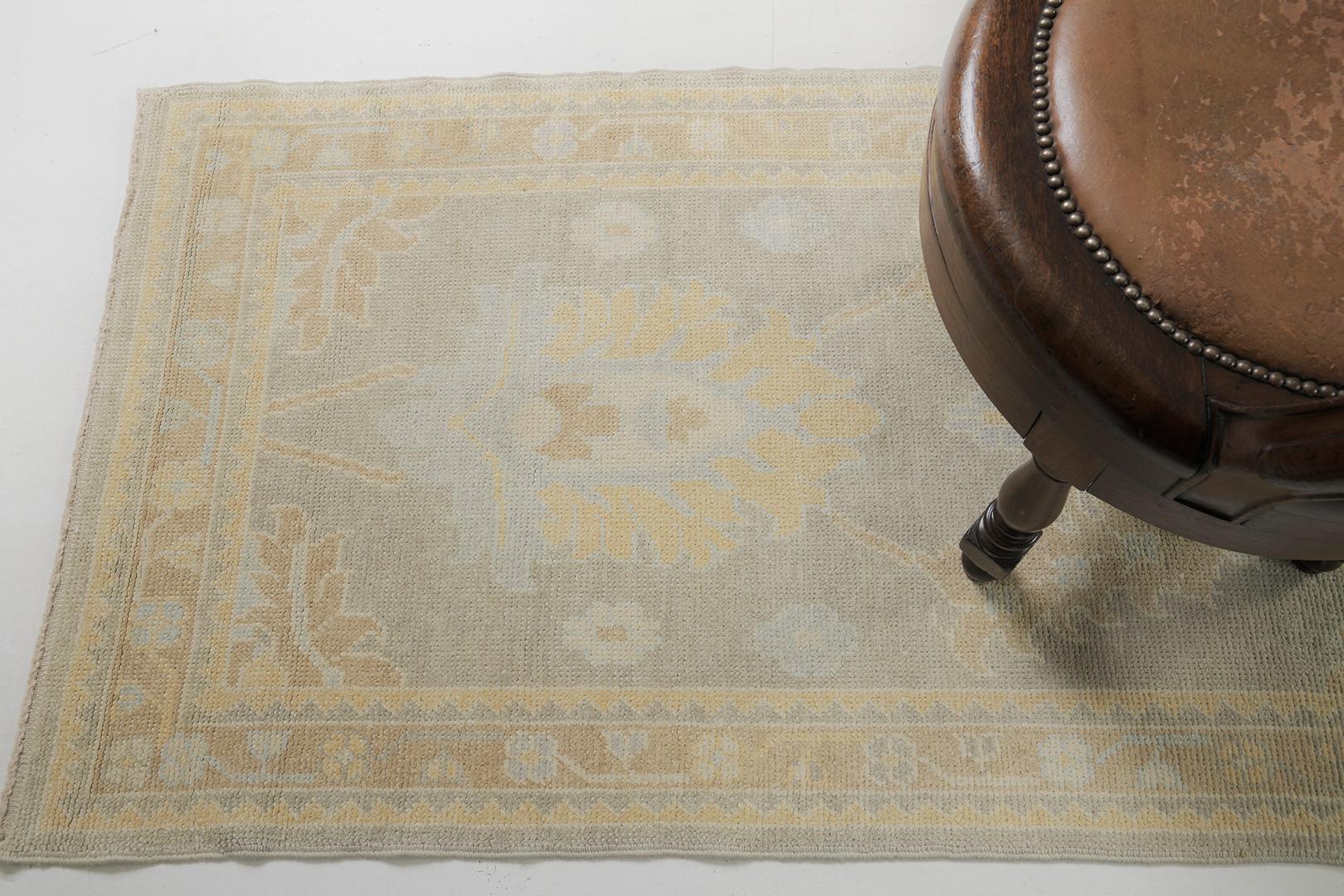 A remarkable Turkish Oushak revival rug that has an illustration of a dainty blossoming vibe. Distinctive palmettes, graceful peonies, and connecting twigs are highlighted in elegance in the stunning shades of gold, sage, coffee, and light blue