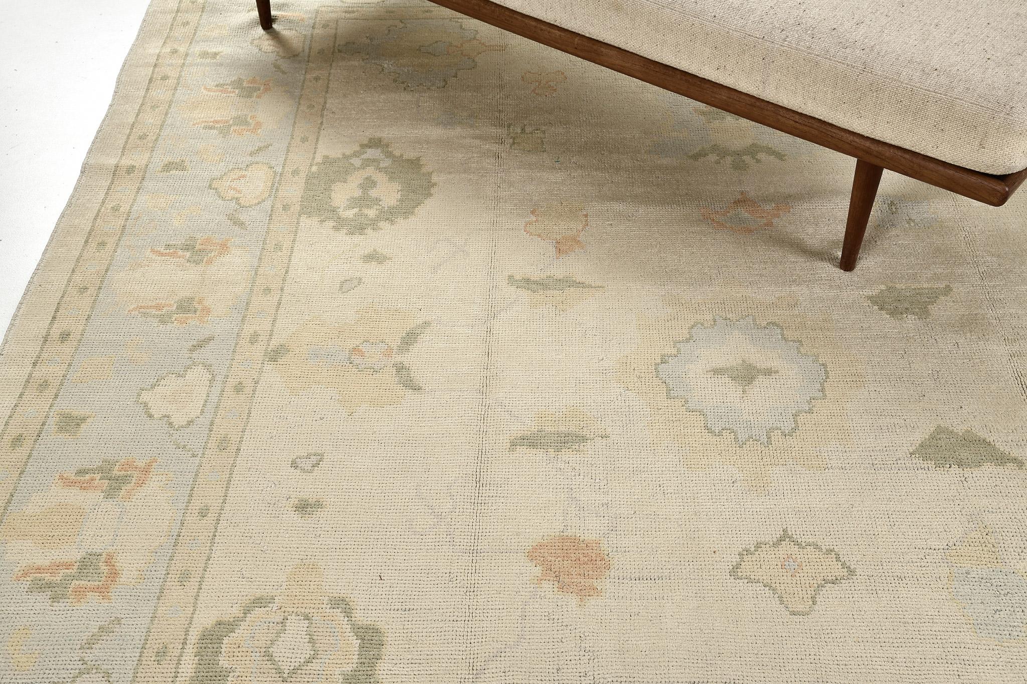 A phenomenal Oushak design revival rug that has a Classic and timeless pattern. Featuring the collaboration of muted tones sky blue and ivory, this classy rug is composed with enchanting graceful palmettes and florid elements that create a