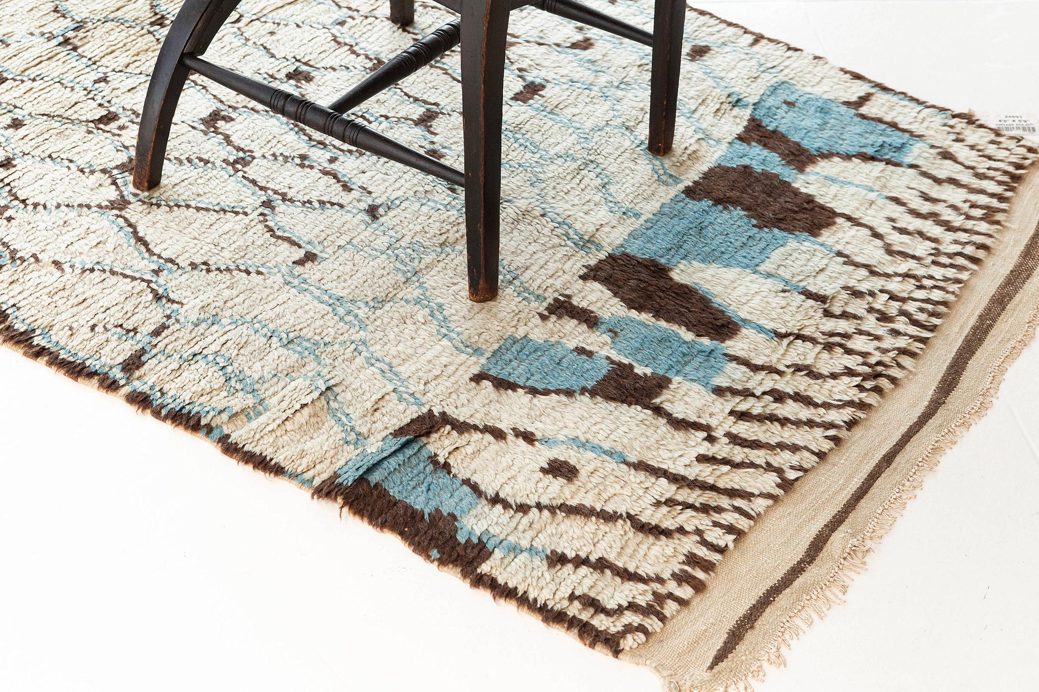 A majestic Moroccan rug in Azilal Tribe that displays a remarkable style reminiscent of a crocodile skin. This fascinating plush rug emanates chic yet sophisticated vibe. The blue outlined lines crisscross in an organic manner, creating a handsomely