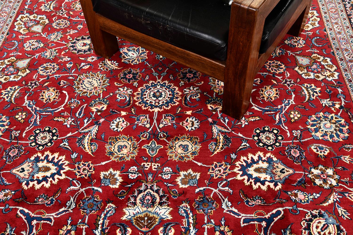 Eine bemerkenswerte Kreation des Kashan-Teppichs, der durch sein Design eine große Wirkung entfaltet. In seinem Kern präsentiert es majestätisch ein detailliertes, symmetrisches Blumenthema, Motive und Blattrollen. Eine mühelose Kombination