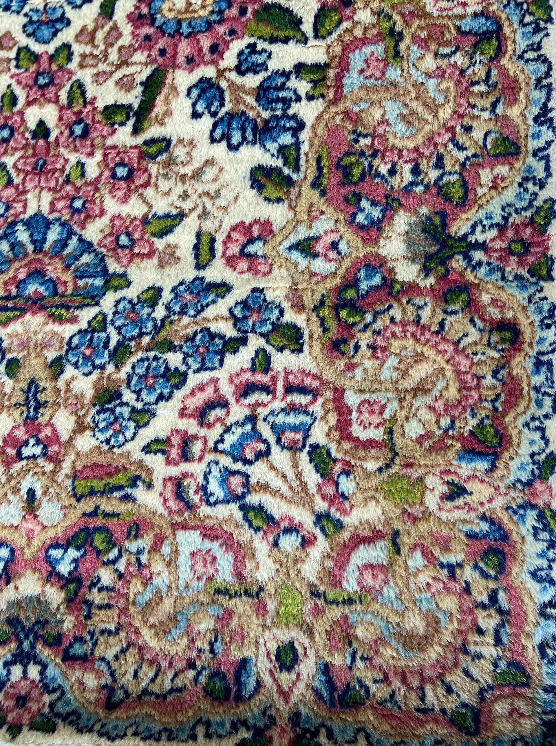 Classically composed and boasting a truly magnificent all-over garden design, this vintage Persian Kerman rug reflects the finer points of timeless Central Asian rug trends. A variety of botanical elements, blossoms and vines are elegantly spread