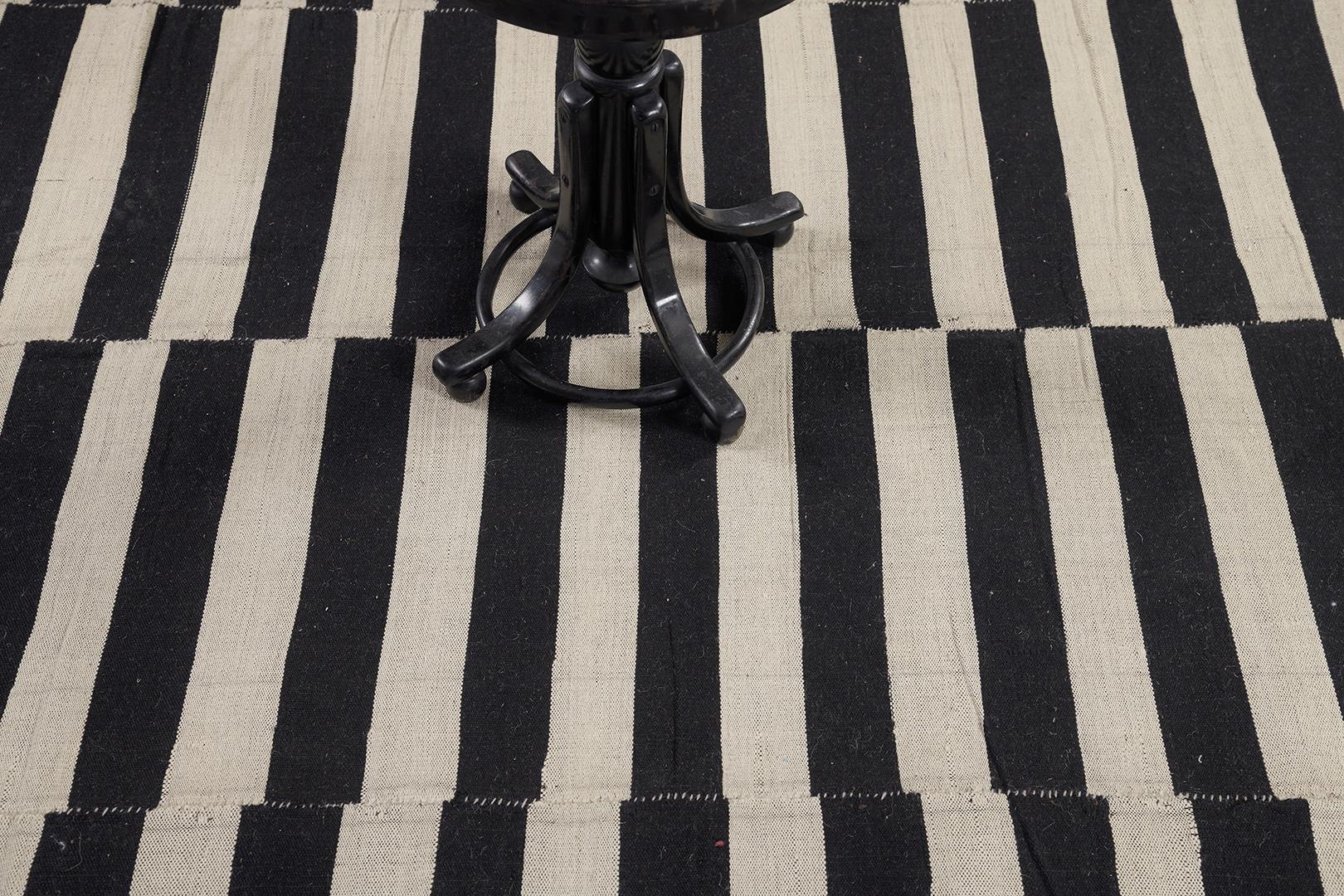 Ein atemberaubender alter persischer Kelim aus Flachgewebe mit Streifen in Schwarz und neutralen Farben. Die unterschiedlich starken Streifen schaffen ein dezentes, aber faszinierendes Design für eine große Vielfalt von Innenräumen. Ein