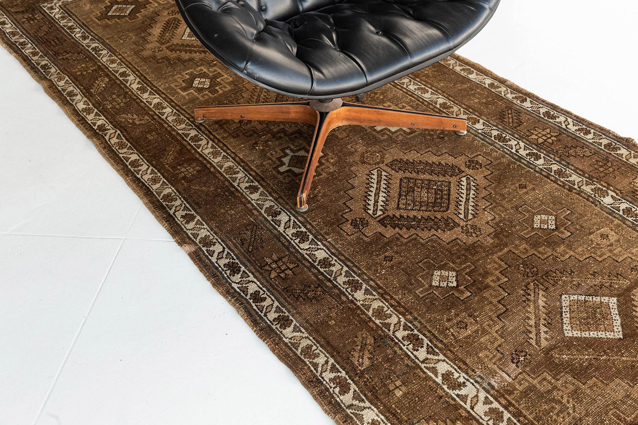 This Vintage Persian Malayer runner features five diamond-shaped medallions spread across an abrashed tan field. The gorgeous color palette based around soft browns and ivory gives the piece a rather refined, yet charmingly rustic feel. In