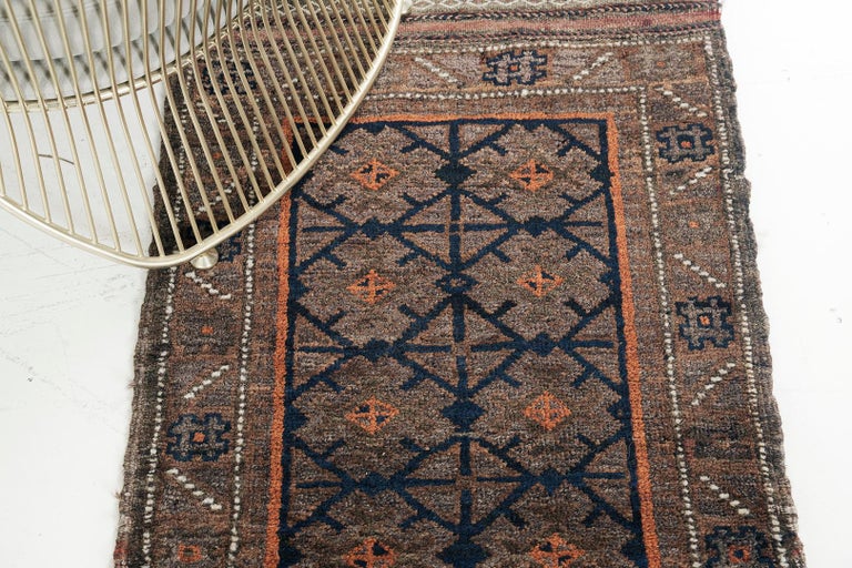 A Vintage Persian Turkoman rug that has a prominent jewel colour palette and intricate symbollical motifs emanating Moroccan elements. This awe-inspiring rug has an amazing tribal pattern of lozenge trellis that gives an ethnic and distinct