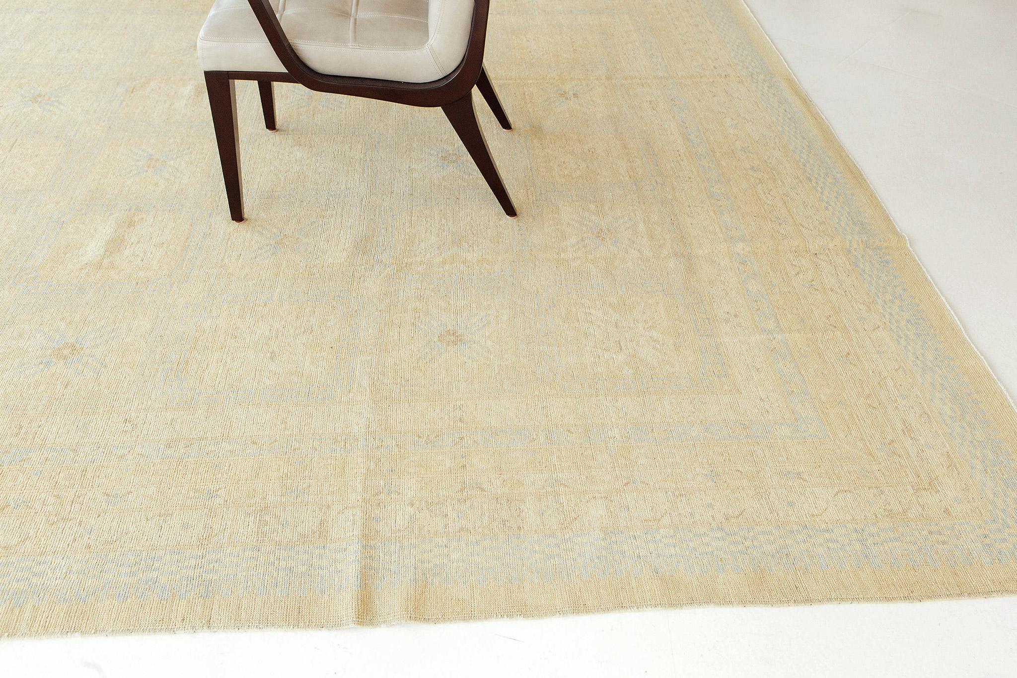 A gorgeous Khotan Panel design recreation. This pieces golden tones and hints of blue create a beautiful and timely piece that will enhance a wide variety of interiors. The repeating square patterns in the rug's field add dimension and elevate the