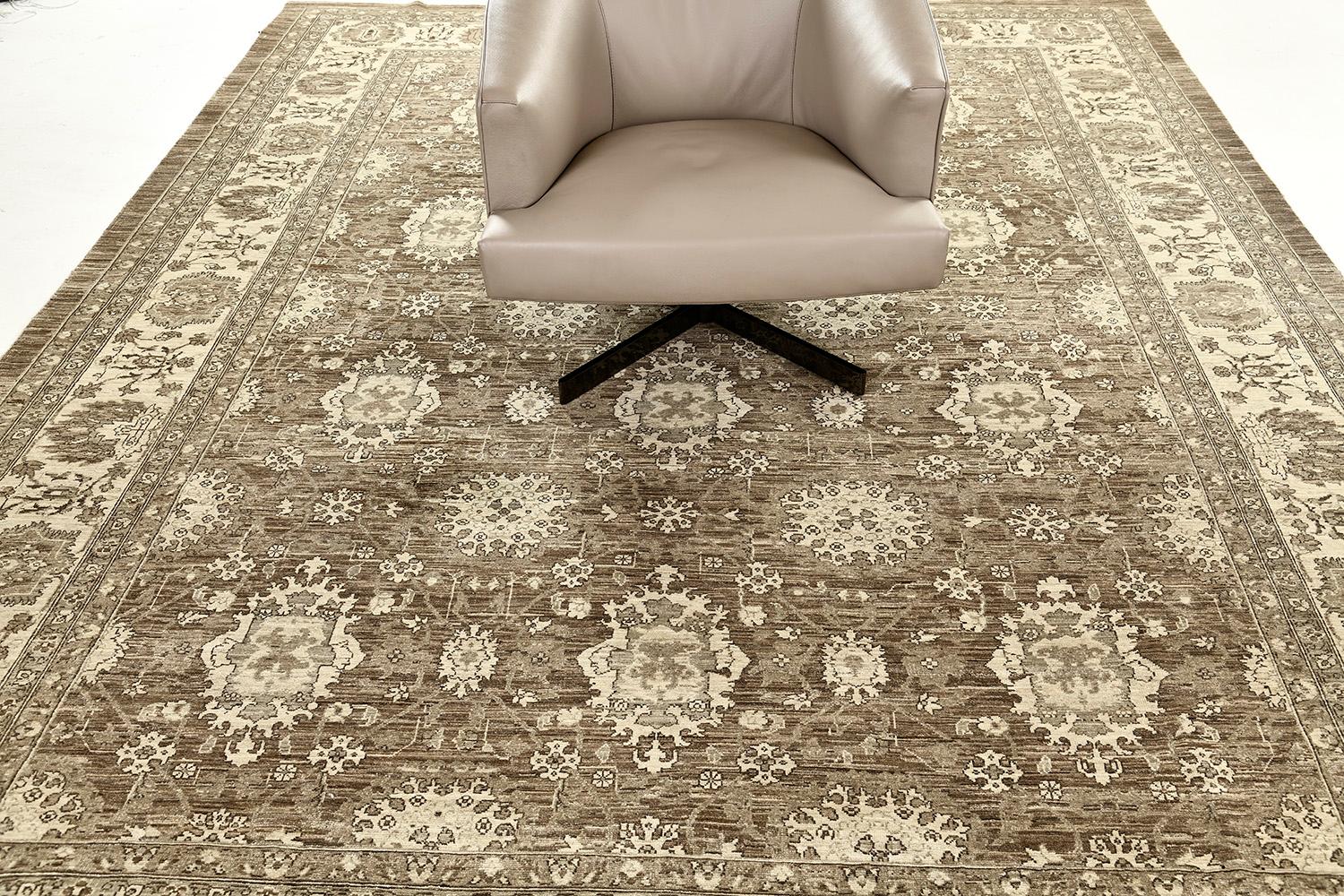 This enchanting revival of the Mahal rug has created an impressive pattern. Featuring the well-coordinated neutral tones and palette of umber brown, this elegant rug is composed of enchanting florid elements forming different grandiose medallions