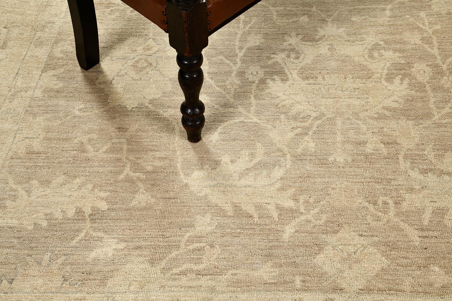 A breathtaking revival of vintage style Oushak rug that features fascinating muted tones of taupe and sand. Boasting its all-over pattern of florid elements composed of blooming palmettes and meandering vines, this rug is a piece that you cannot