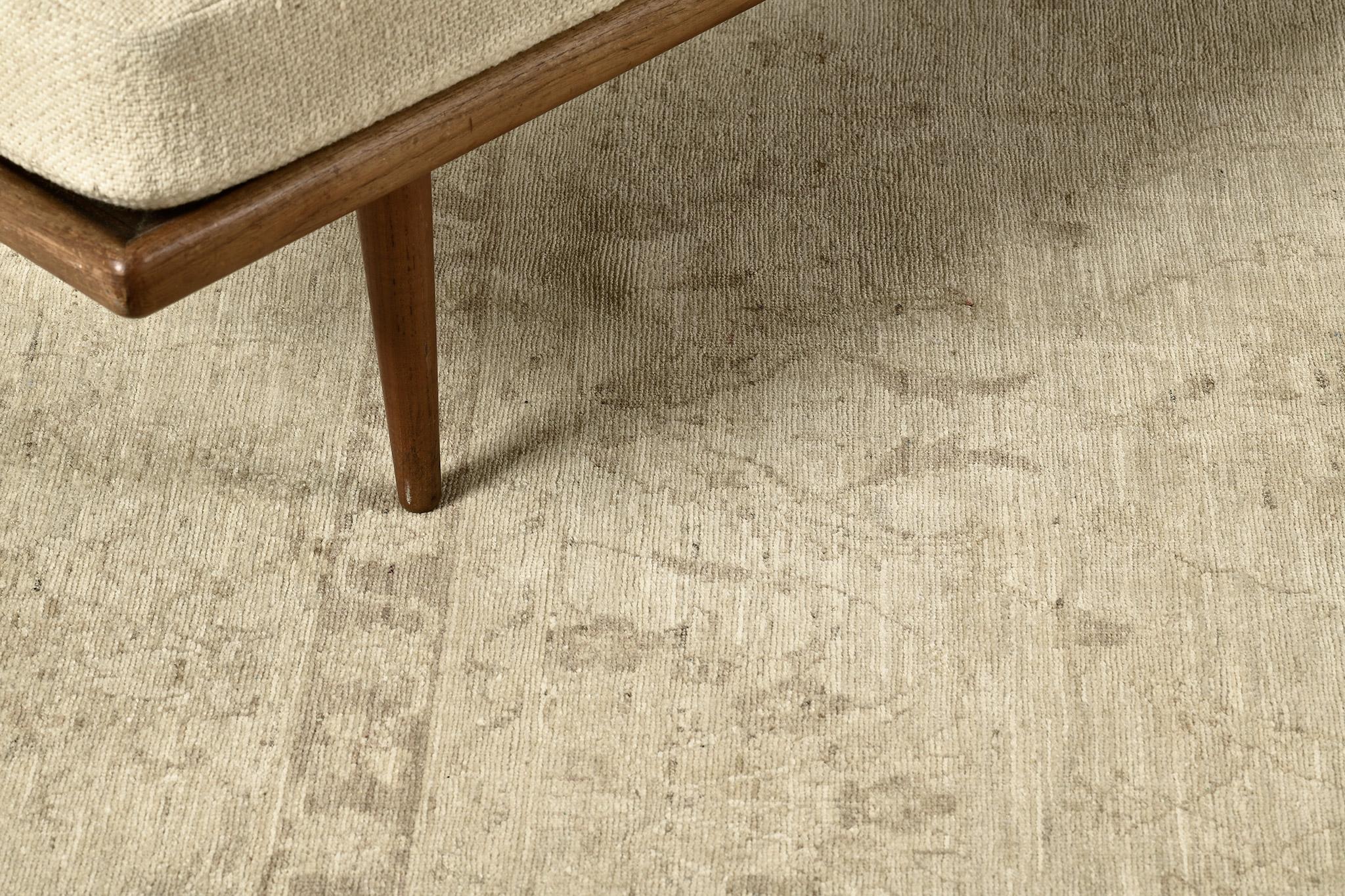 A stunning Oushak design revival rug that has a classic and timeless pattern. Featuring the collaboration of muted tones of sand and taupe, this sophisticated rug is composed with enchanting graceful palmettes and florid elements that create a