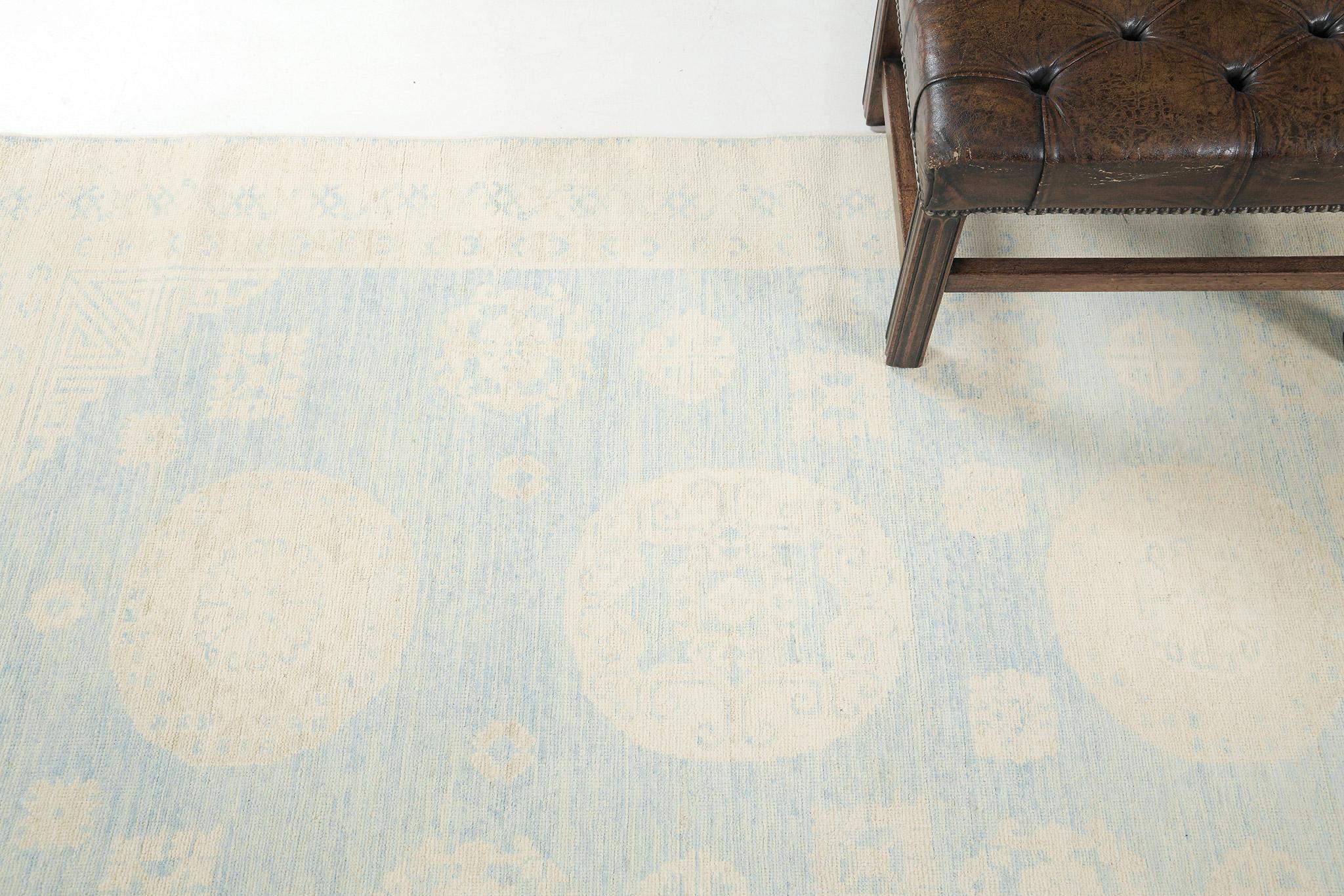 A recreation in the vintage style of a Khotan Design Rug, ideally suited for a floor wall piece. Five grandiose medallions and symmetric motifs in camel tone outlines are aligned that have spaces in a cerulean blue field. From borders to the field,