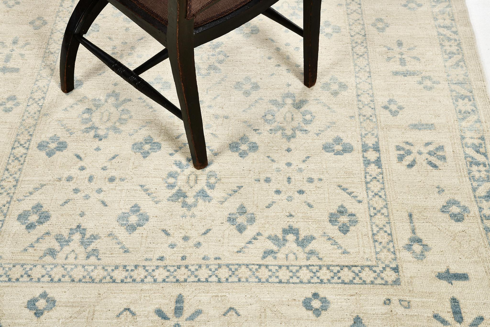 A vintage style revival rug in Safira Collection featuring the muted tones of sand and aegean blue. All-over pattern of blossoming palmettes and botanical patterns are enclosed by borders of various ornate elements that blend together in harmony. A