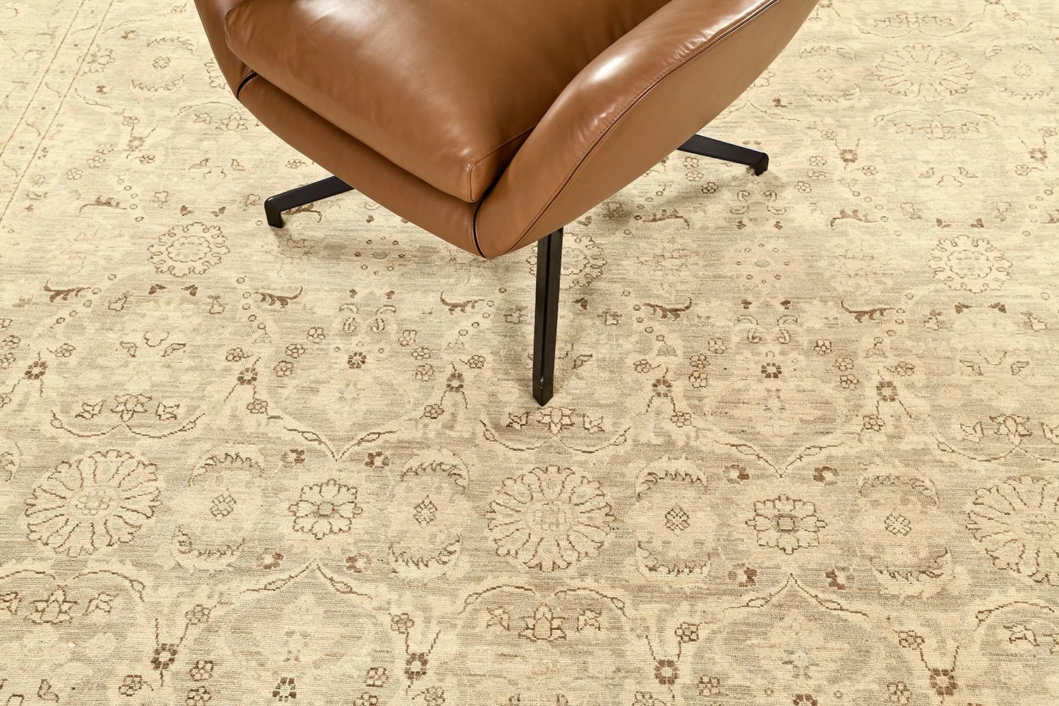 A graceful revival of Tabriz revival rug that establishes refinement through the all-over botanical patterns of the blooming palmettes, various stylized florals and leafy tendrils. Flanked by inner and outer floral guard bands, this glorious rug is