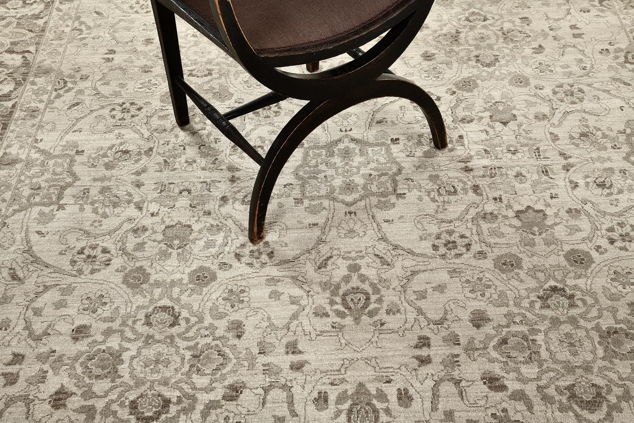 Through the use of the cool tones of muted colours, this captivating revival of Traditional Design rug emanates understated elegance. Artfully made from hand spun wool bears the ornate borders of serrated leaves and blooming palmettes followed by