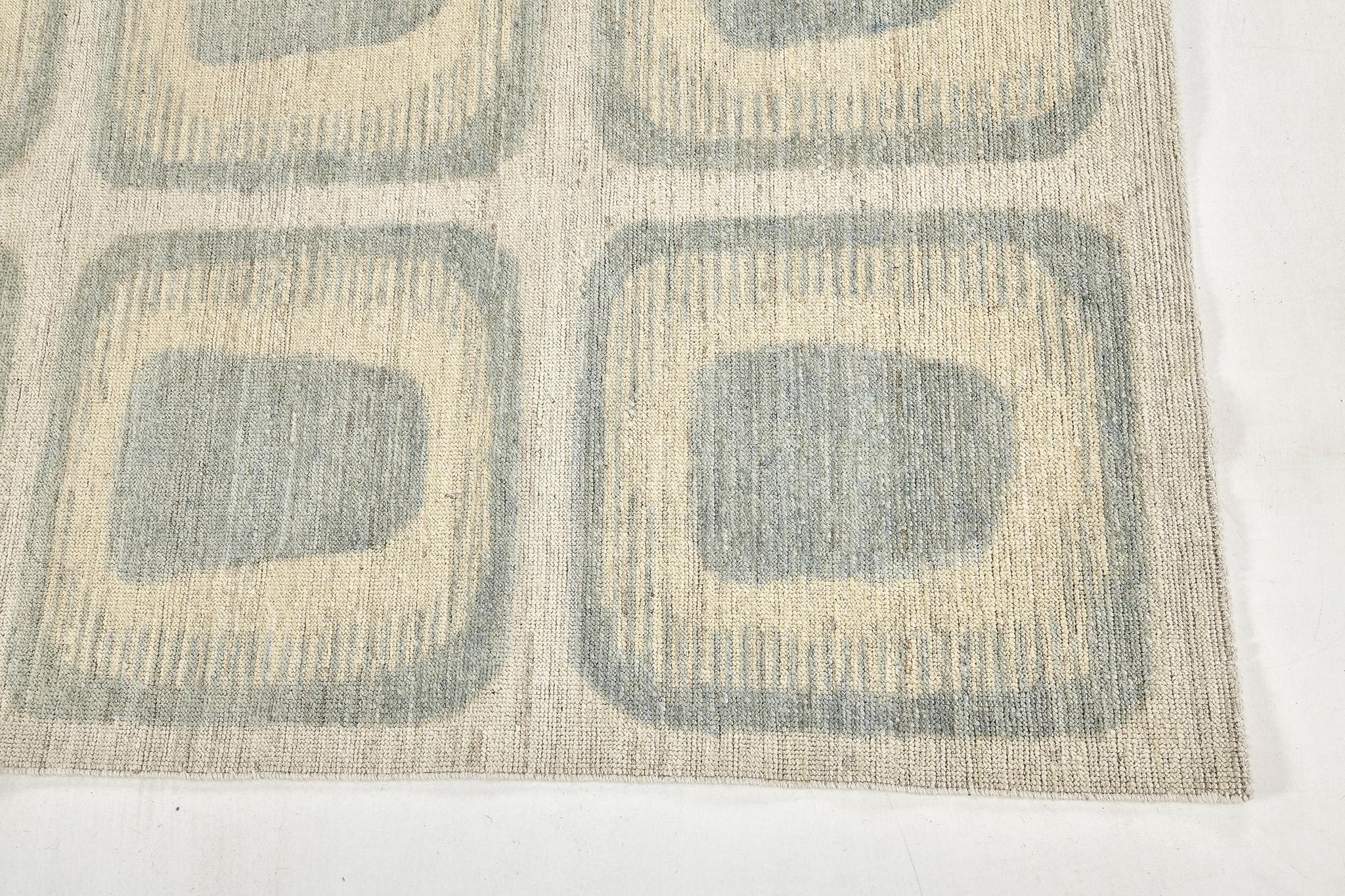 A transitional design rug that features the muted tones of dusty blue and cream. Panel design of bold geometric patterns work together creating an overall sense of symmetry and simplicity. Whether used as an ornamental background element or a