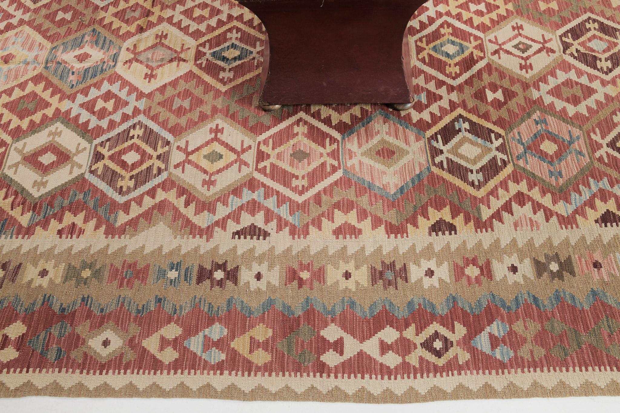 A gorgeous vintage-styled flatweave Kilim is banded with brick palette diamonds that consist of traditional motifs and symbols. The palette of diamonds creates a festive and interesting design for a vast variety of interiors. This such kinds of rugs