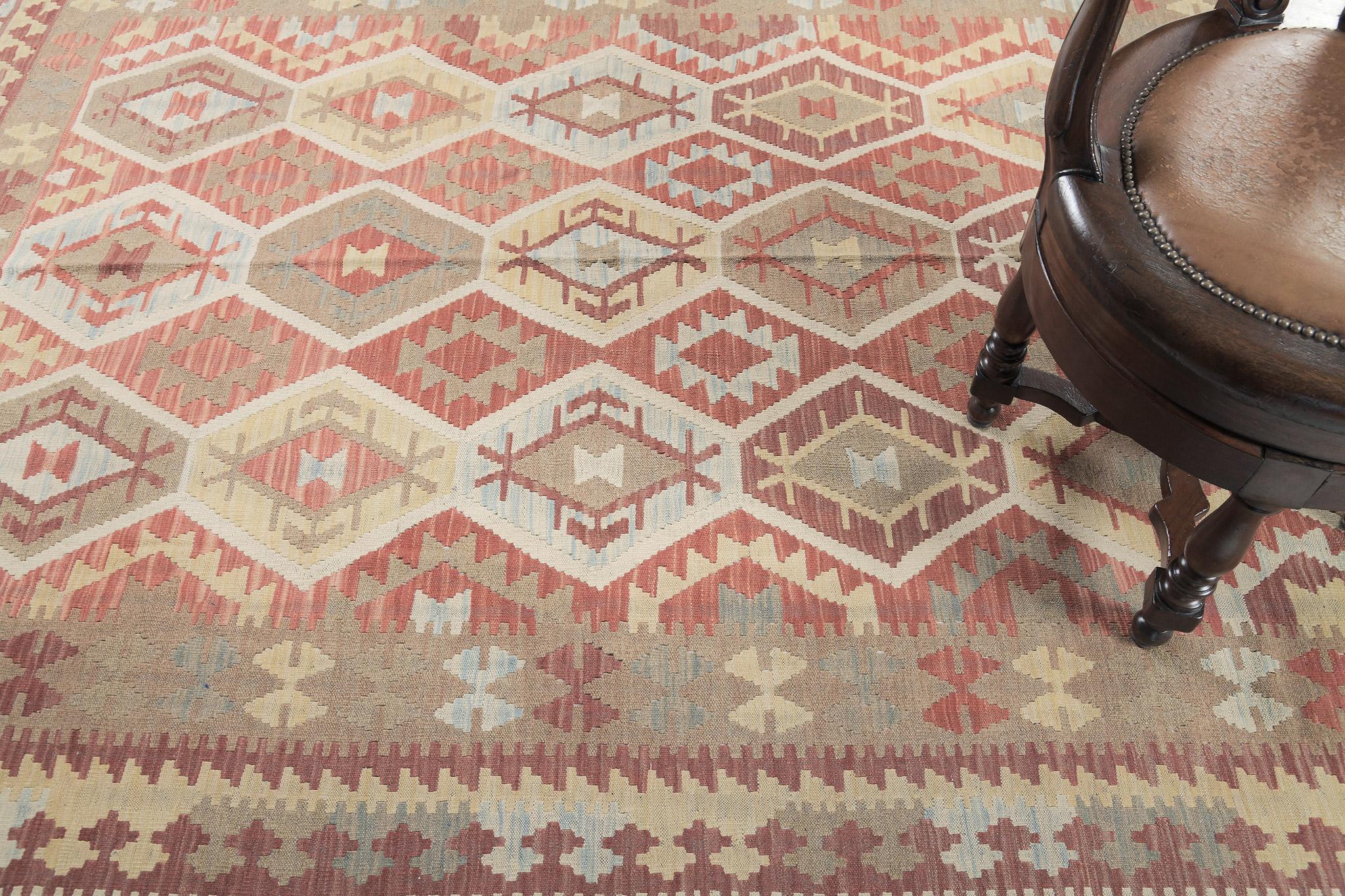 Los motivos geométricos crean un diseño alegre y encantador para una inmensa variedad de interiores. Este asombroso kilim de tejido plano de estilo vintage presenta motivos geométricos a través de una paleta de tonos cálidos. Una obra maestra que
