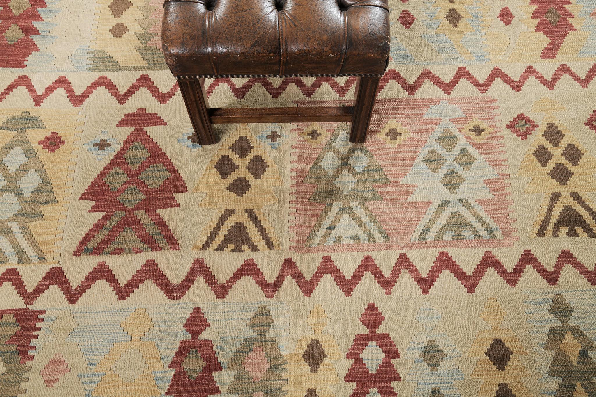 Noting a remarkable effect creating a powerful story, this flatweave Kilim rug adds texture and modest graphic appeal forming a festive but relaxed space. The field is covered in a zigzag pattern and multicolored diamonds. Displaying a stunning