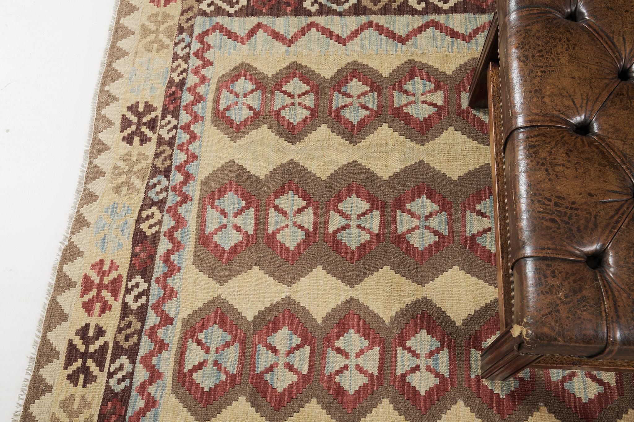 The motifs are in hexagon patterns that create a joyous and impressive design for a vast variety of interiors in a yellow field. A stunningly beautiful vintage-styled flatweave Kilim is banded with zigzag patterns and geometric motifs in alternates