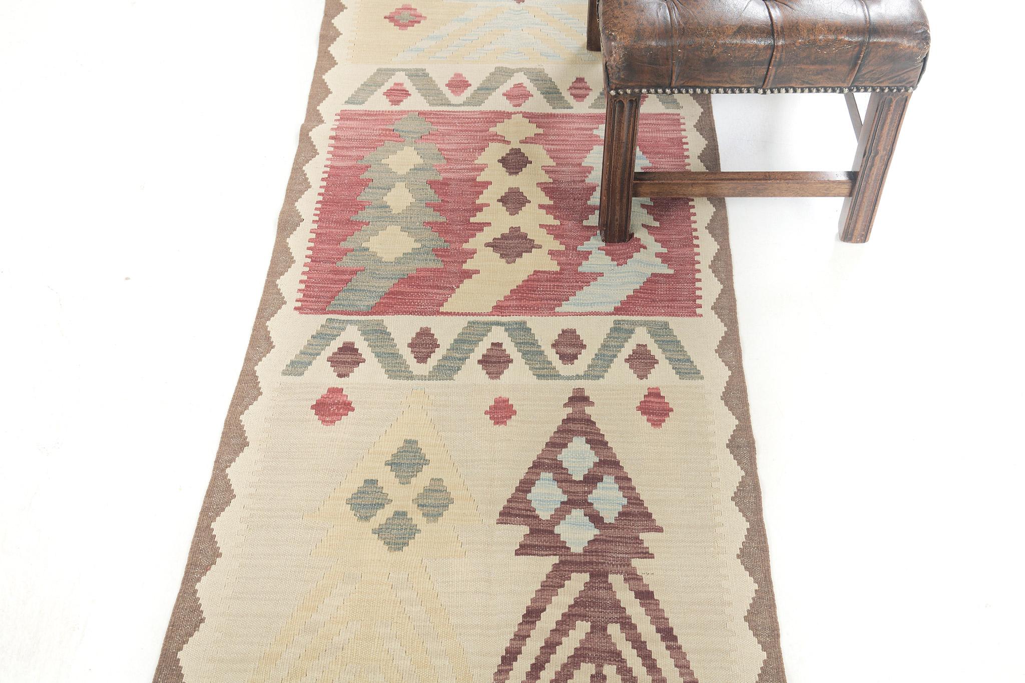 Our natural dyed flatweave Kilim in vintage style rug is inspired by tribal patterns. This Kilim is a deal for flooring or wall applications. It is adorned with motifs and tribal symbols and surrounded by zigzag patterns that make this rug loved by