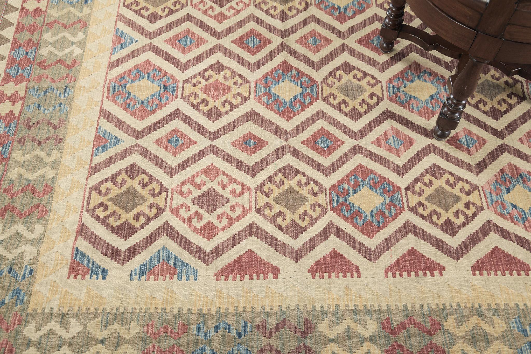 Stylized motifs and geometrical designs are aligned and woven meticulously. This flatweave kilim features tones of gray, yellow, red, and blue with white and gray zig zag. A home decor that is perfect for your home and surely adored by your