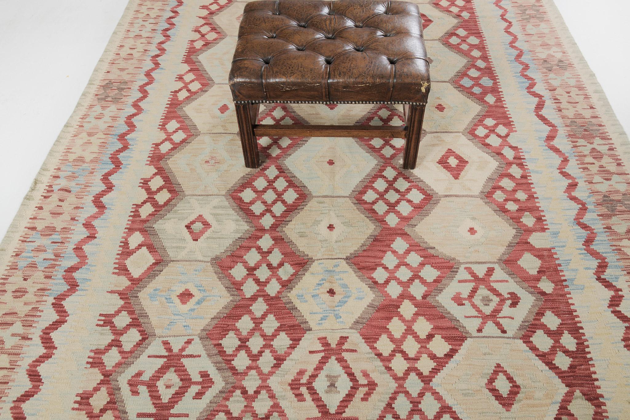 A stunning vintage-styled flatweave Kilim is banded with zigzag patterns and geometric motifs. The diamond motifs are in hexagon patterns that create a festive and fascinating design for a vast variety of interiors in a bright red field. A
