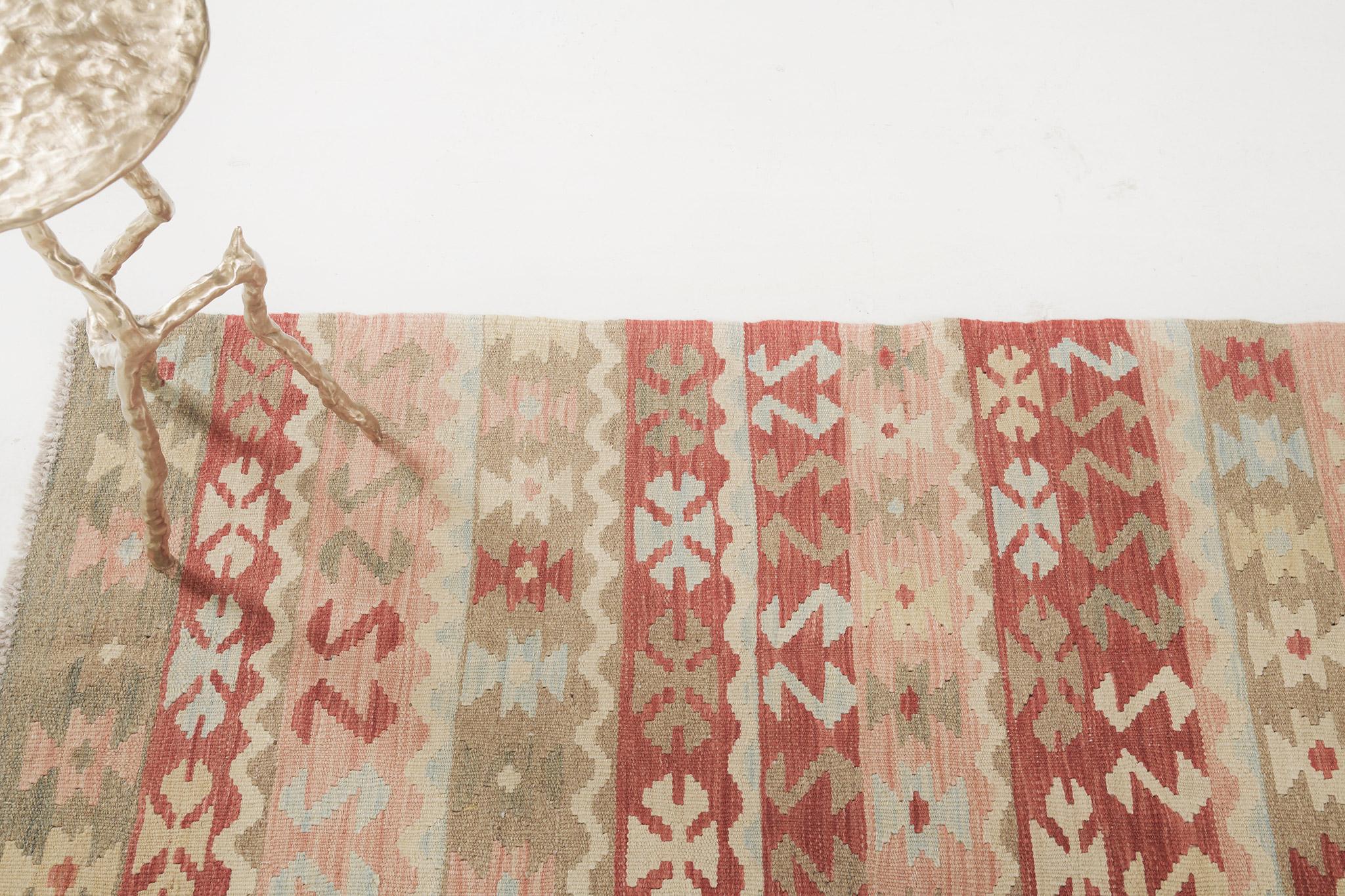 Holen Sie sich diesen flachgewebten Kelim im Vintage-Stil für Ihre Räume. Es verleiht ein lebendiges und festliches Ambiente in mehrfarbigen Schemen. Die Motive des Hakens, des Wolfsmauls, des Sterns und der Kurven sind reichlich vorhanden und