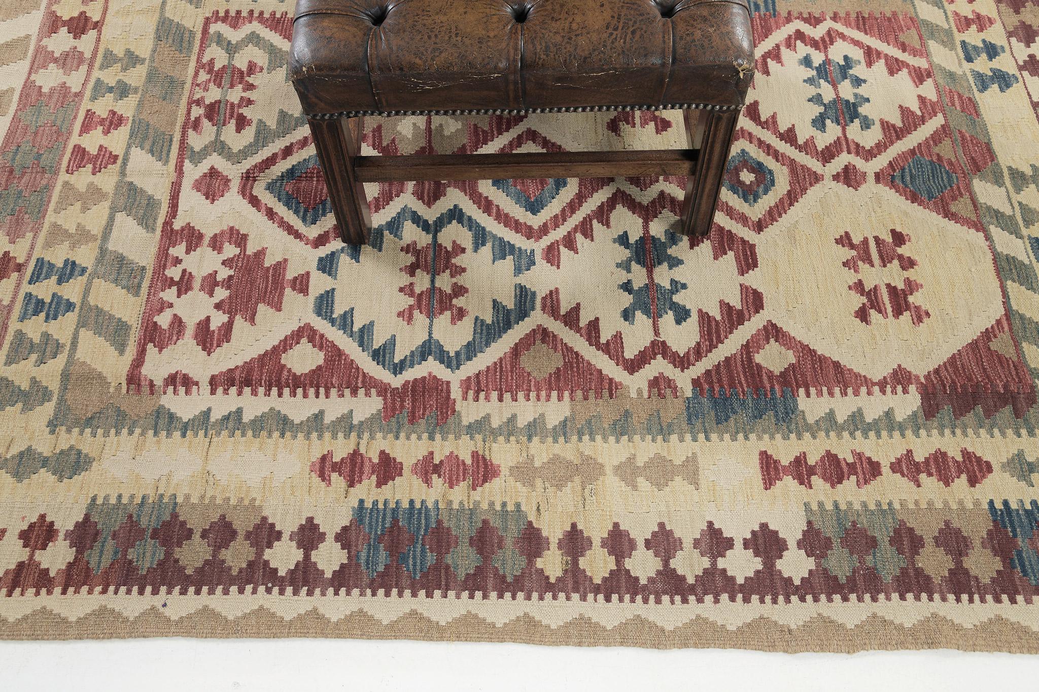 This remarkable flatweave Kilim is an excellent choice for your floors. It is not just for aesthetic value, but, to keep you on fashion as well. It features an all-over design of tribal motifs over dazzling multicolored wool. A beautiful hand-woven