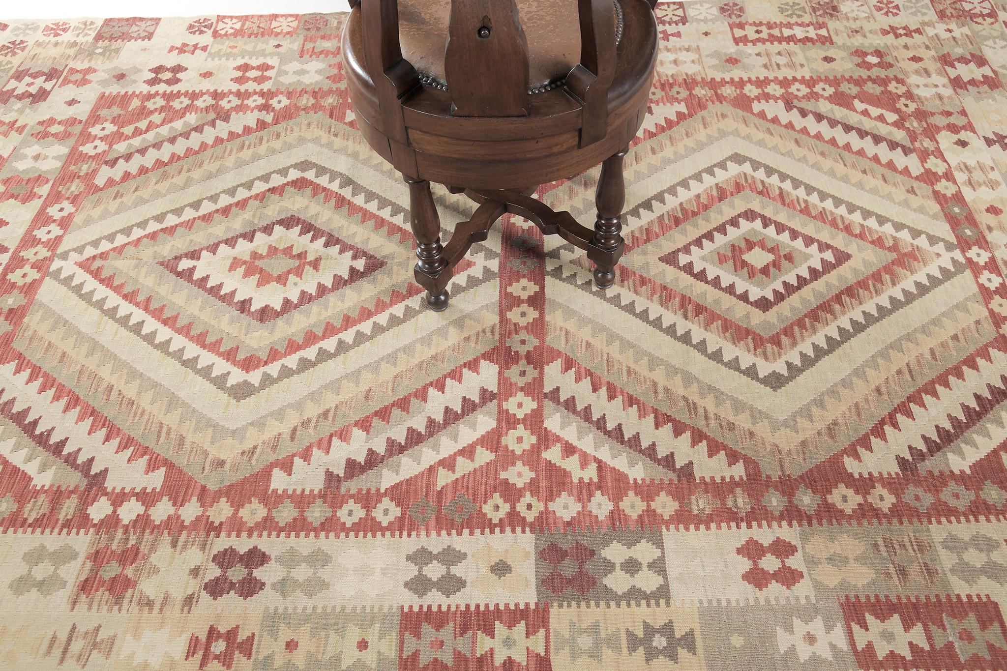This impressive flatweave kilim features diamond patterns in the mirrored pattern. Surrounded by remarkable motifs and symbolic geometric patterns, this vintage-styled kilim out your room spaces attractive. A masterpiece that is a must-have in your