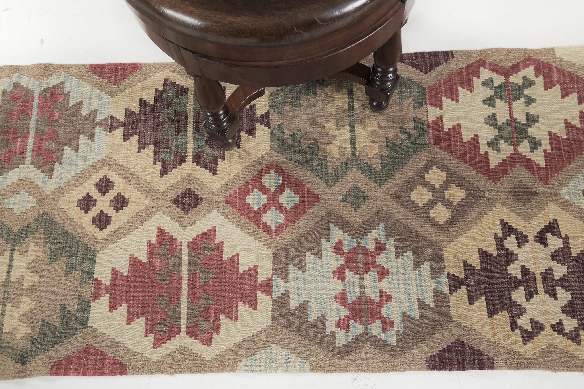 Ce superbe Kilim à tissage plat de style vintage présente un motif sur toute sa surface, composé de motifs et de symboles traditionnels. Les couleurs multicolores créent un design festif et intéressant pour une grande variété d'intérieurs. Ce type