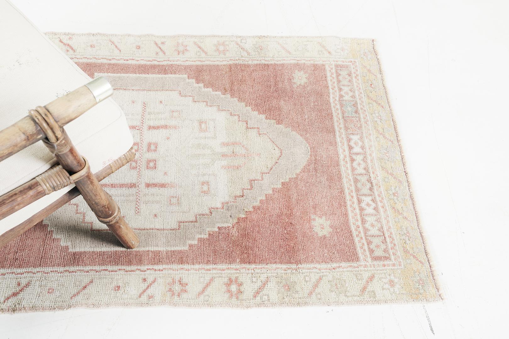 Un affascinante tappeto vintage turco anatolico, meticolosamente tessuto con lana filata a mano e tintura vegetale. Il maestoso medaglione esagonale a losanghe composto da elementi simbolici mette in risalto l'unicità di questo capolavoro. Racchiuso
