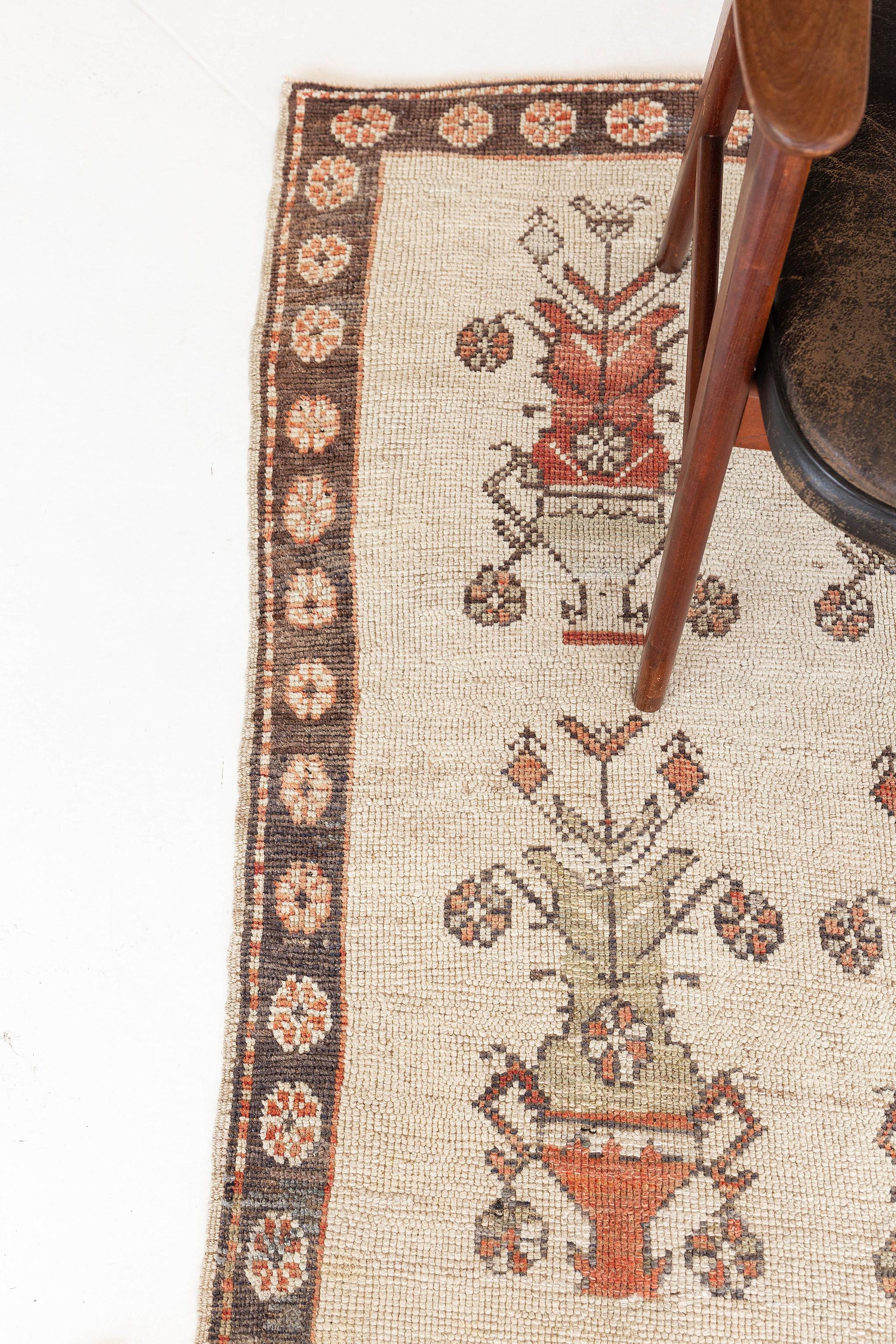A majestic Vintage Turkish Anatolian Rug that has a Classic and timeless pattern. Featuring the collaboration of vibrant tone in terracotta and the magnificent colour palette consisting of ecru and umber brown, this elegant rug is composed with