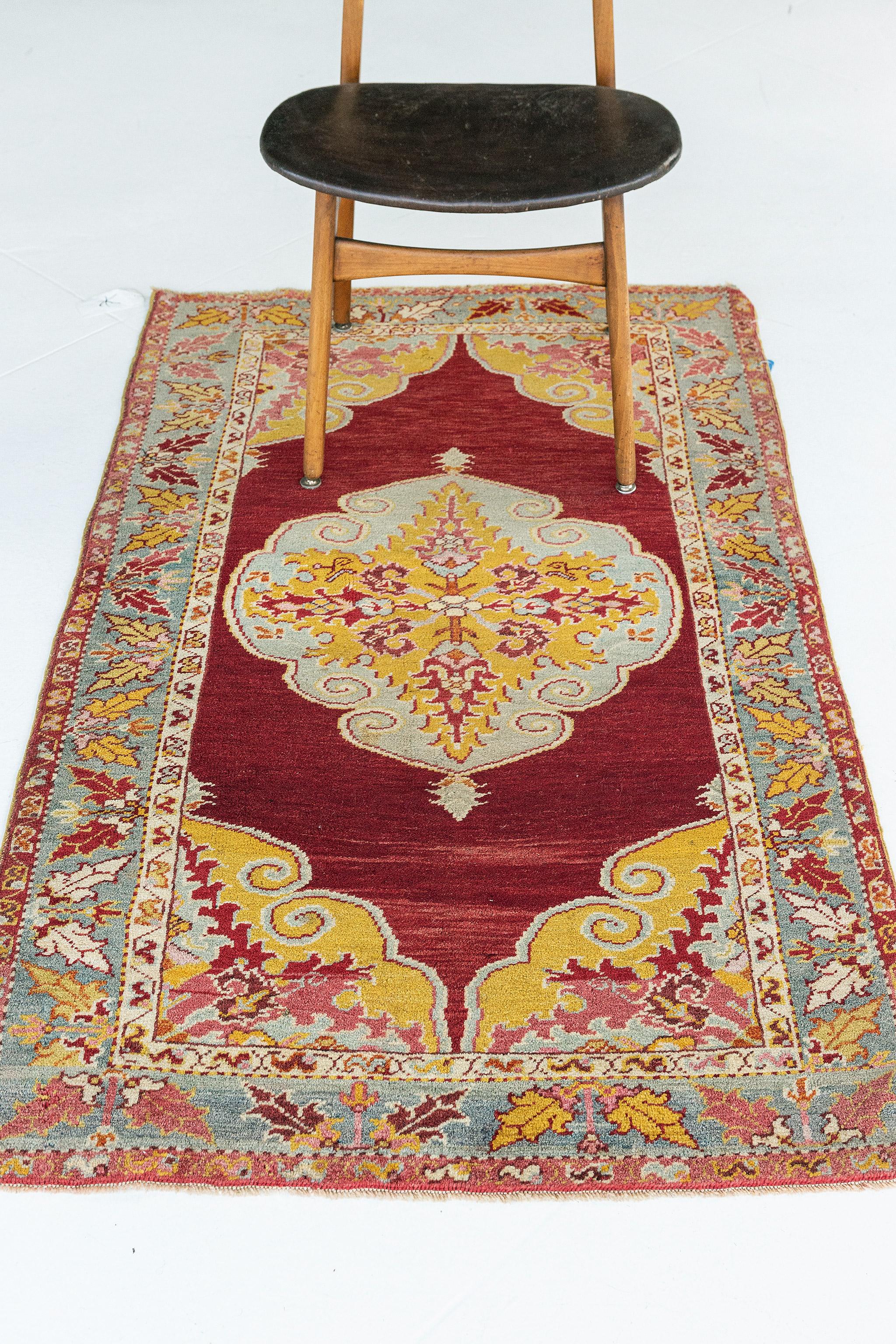 Impressive in style, this Vintage Turkish Anatolian rug features an overall luxurious composition depicting age-old Anatolian motifs. Taking center stage is a lozenge central medallion patterned inside with iris and stylized florals. A rectilinear
