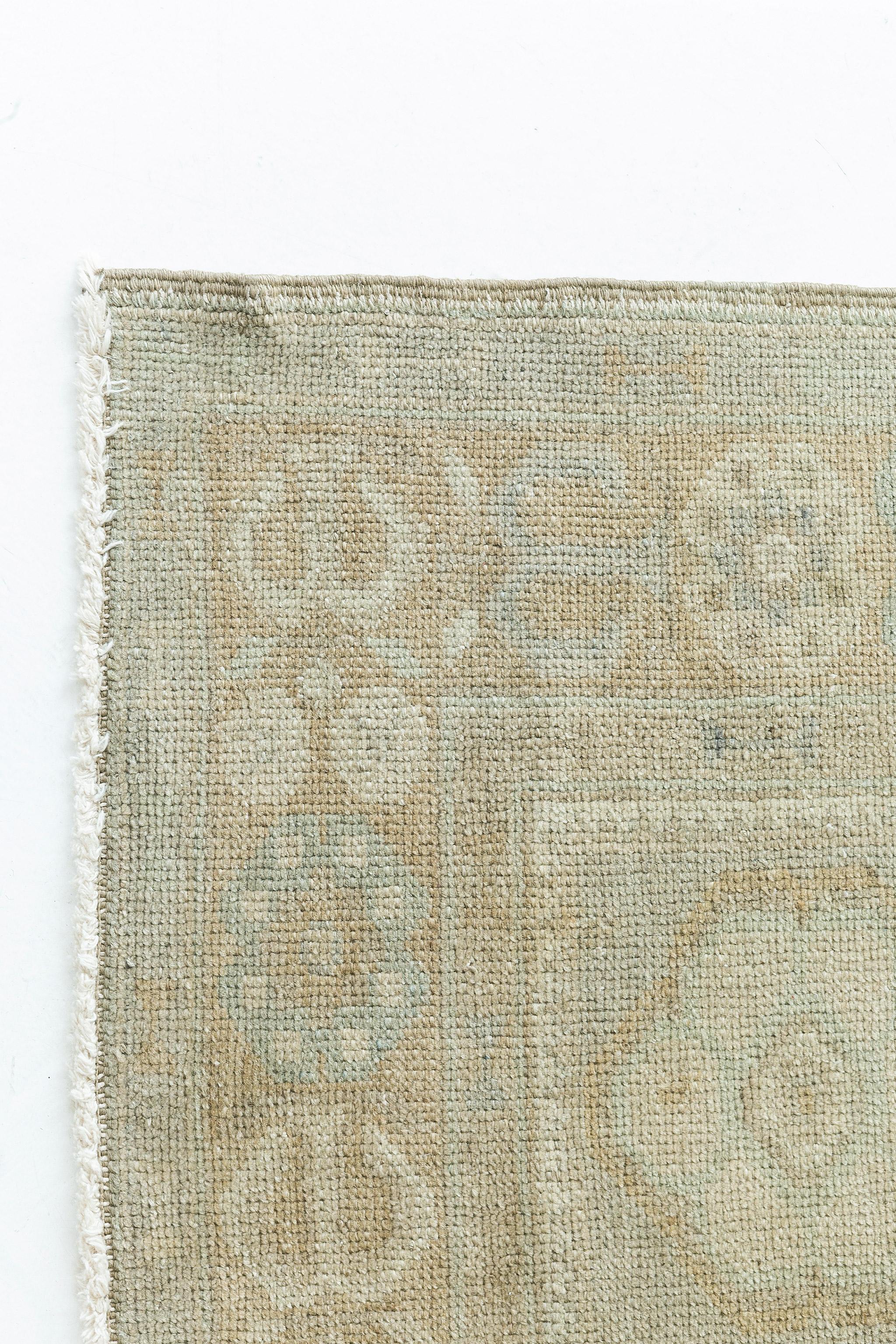 A Vintage Turkish Anatolian rug that features two distinctive cross lozenge cusped botanical medallions composed of palmettes, blossoms and thin angular vines dancing rhythmically. A stylized botanical Meander border flanked with inner and outer
