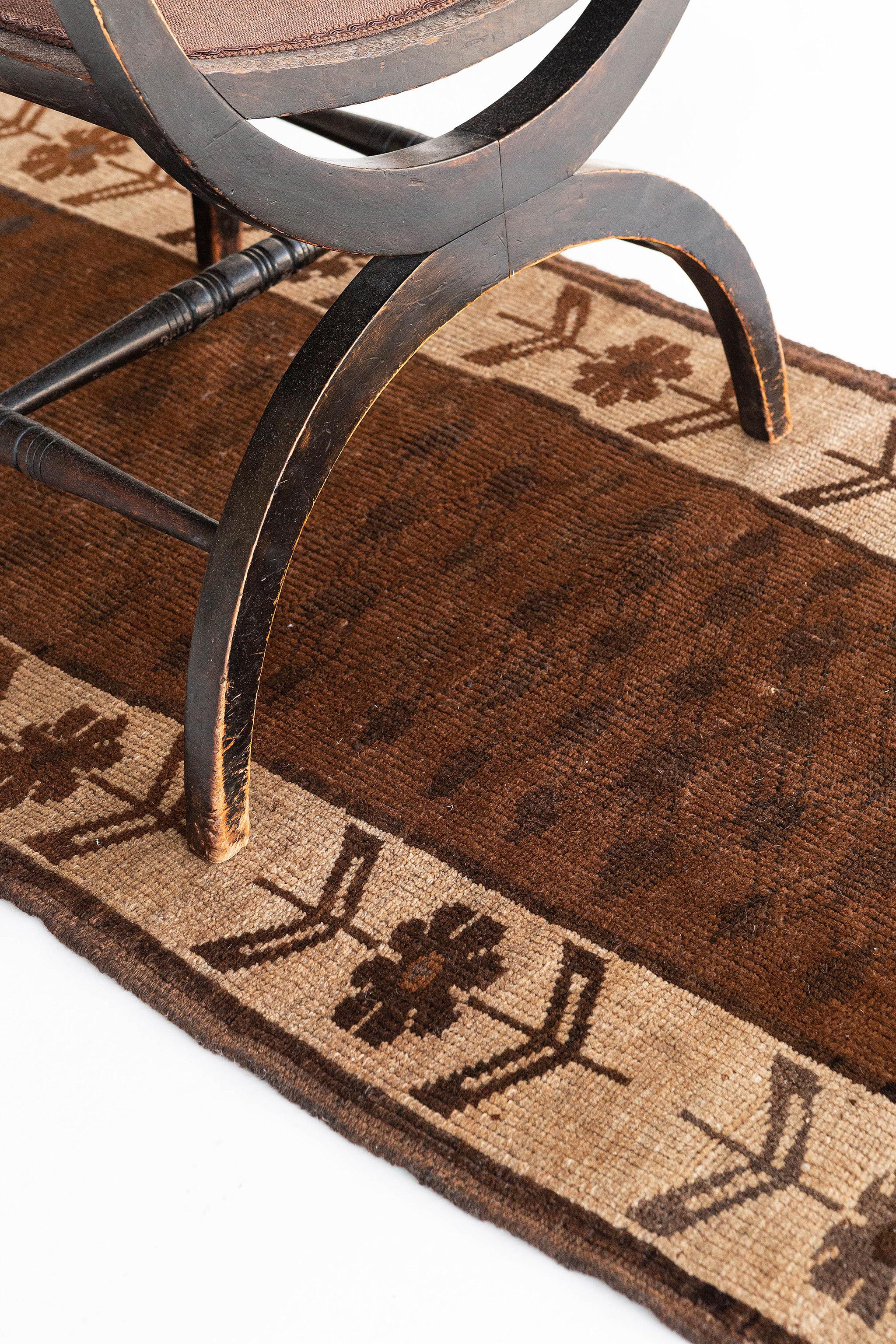 Mostrando una elegancia atemporal en una paleta de colores terrosos, esta alfombra Vintage turca de Anatolia presenta un estampado integral de estilizadas flores interconectadas a lo largo del campo marrón ámbar. Las gradaciones abrasivas naturales