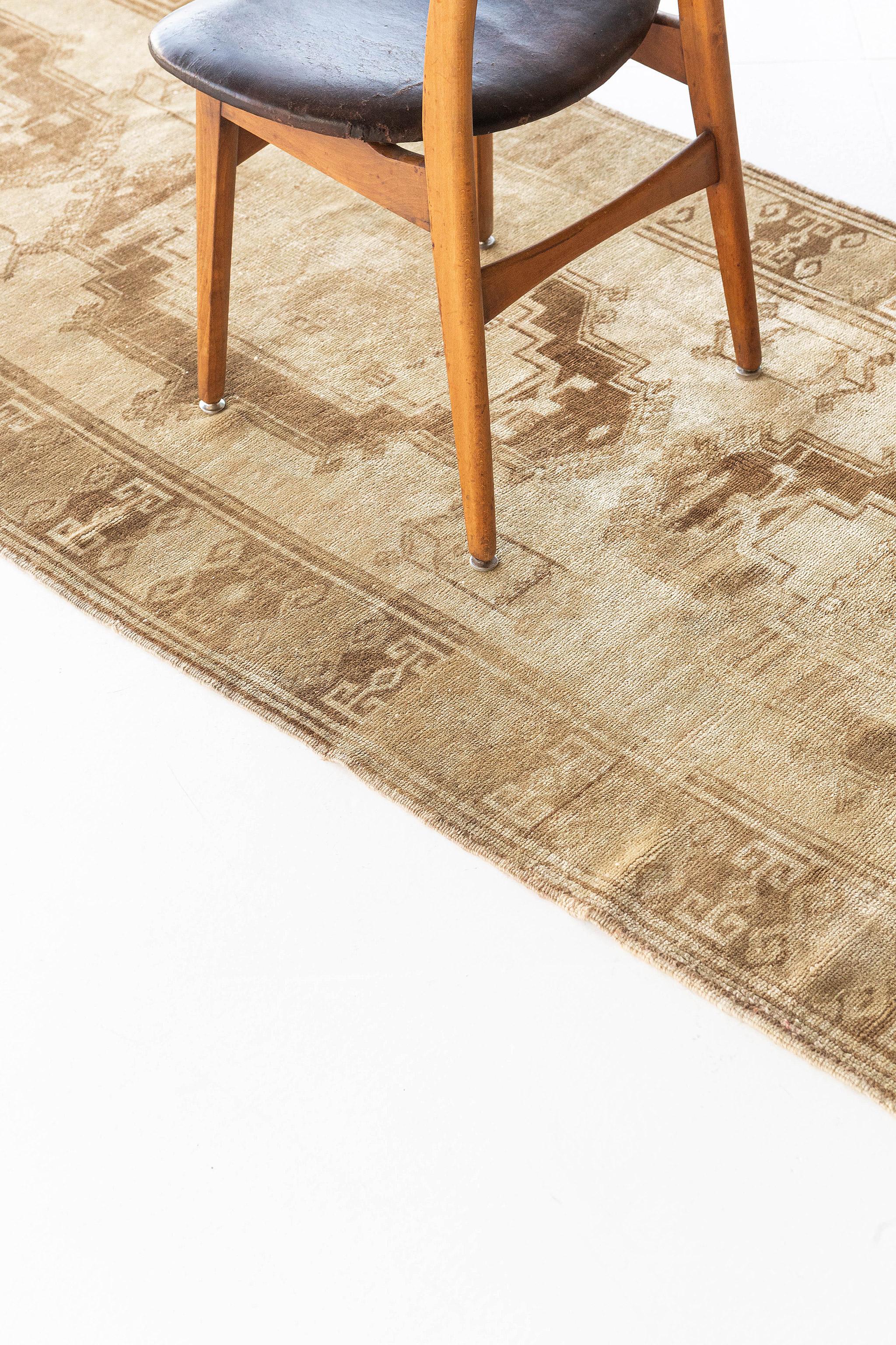 This Vintage Turkish Anatolian Runner features three distinctive lozenge cusped medallions composed of blossoms and geometric formations collaborating rhythmically. A stylized Ram’s horn meander border create a frame for this work of art. This