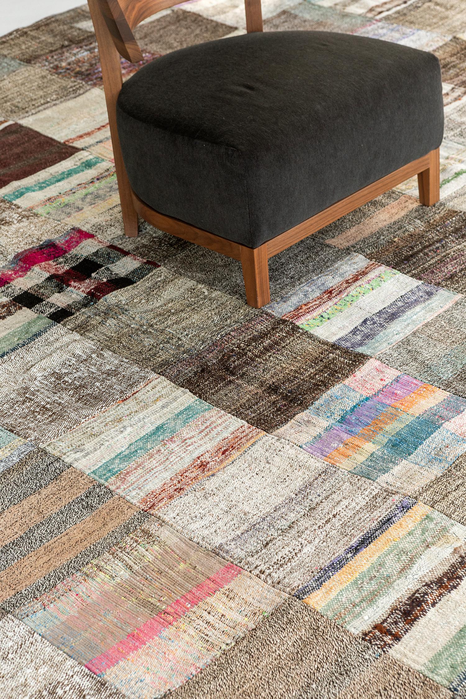 Displaying a charming and captivating appearance, this Vintage Turkish Kilim Patchwork rug is an embodiment of modern rustic preppy style. The patchwork pattern is composed of intricately designed variegated symmetrical squares composed of beautiful