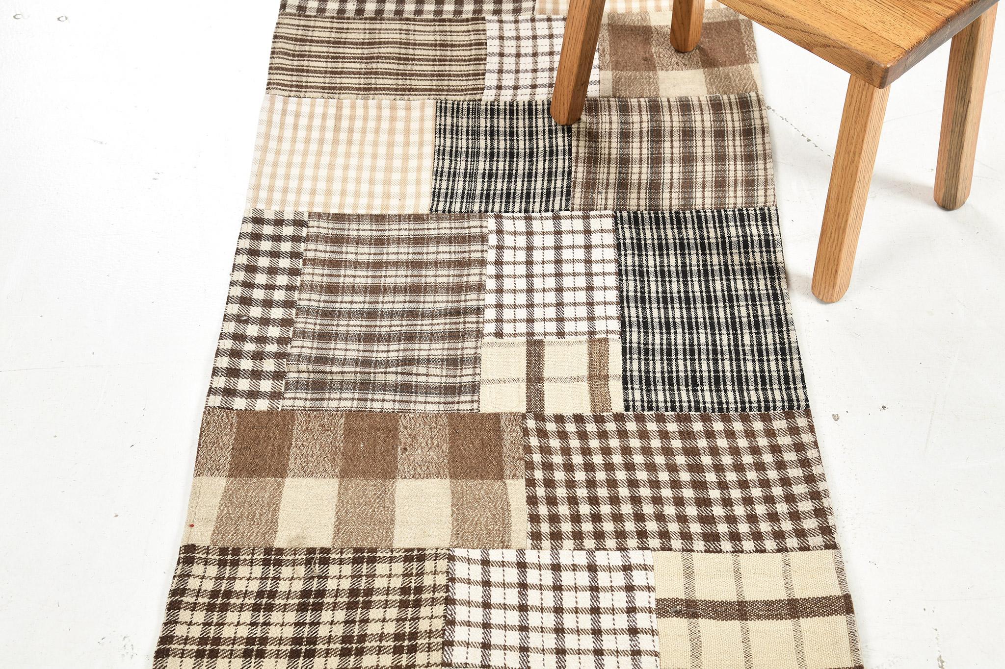 A stylishly impressive hand-spun wool Turkish Patchwork Kilim has immensely flexed its series of the band along the perimeter of checkered features. It is adorned by linear motifs of earth tones. The natural color scheme is perfect for a