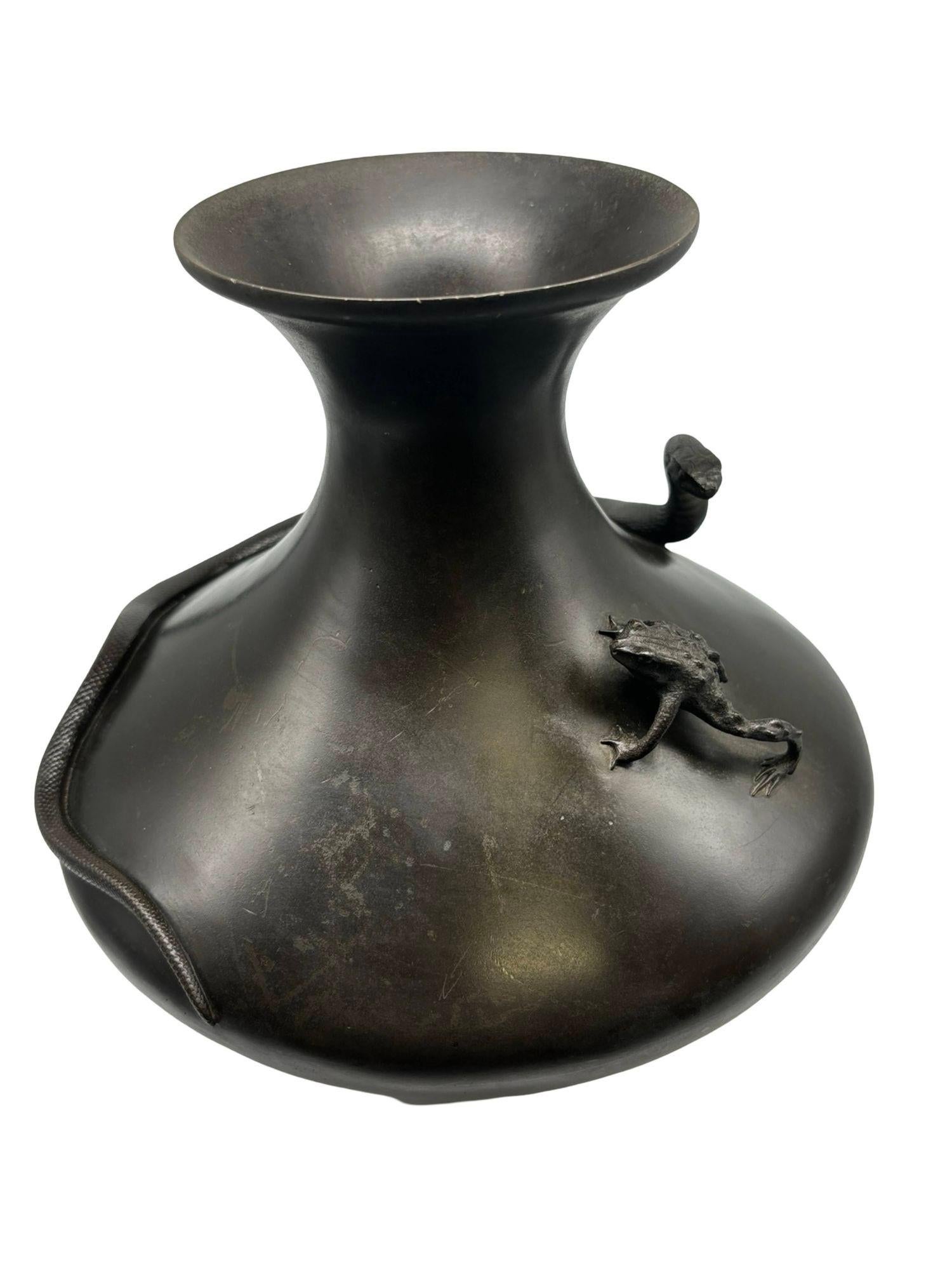 This late 19th-century Meiji Era (1868-1912) Japanese bronze baluster vase with a flared neck, first hand-cast then later hand chiseled to give further intricate detail. The cylindrical form highlights the dramatic hunting scene of a snake hunting a