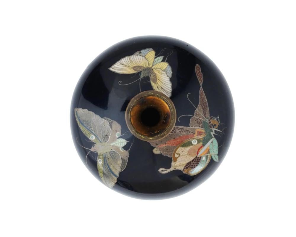 An antique Japanese, Meiji era, Silver wire enamel vase attributed to Hayashi Kodenji, Japanese, 1831 to 1915. Circa 1900s. The baluster form vase is enameled with polychrome images of butterflies made in the Cloisonne technique on a black ground.