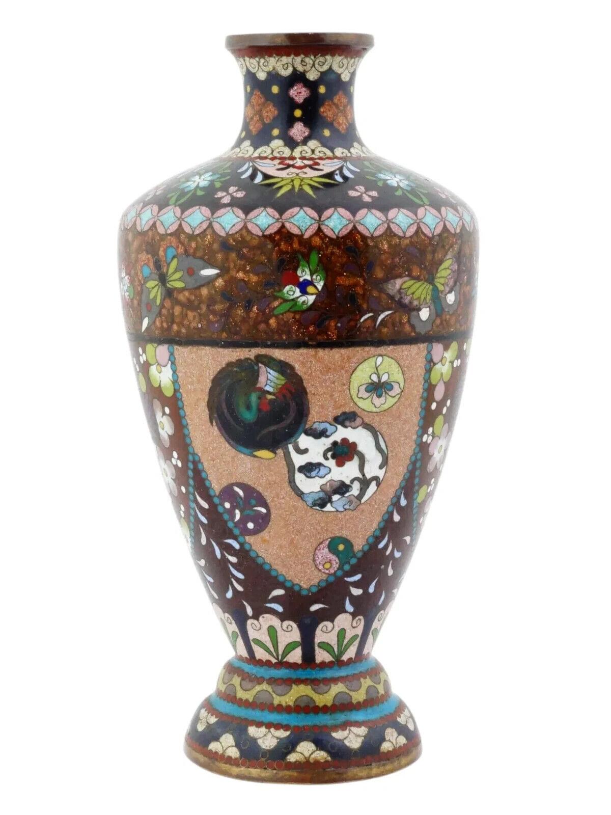 Jarrón japonés con pie, esmaltado sobre cobre. El jarrón en forma de urna está esmaltado con medallones policromos que representan ornamentos florales, de follaje, volutas foliadas, mariposas y aves fénix, realizados con la técnica cloisonné. La