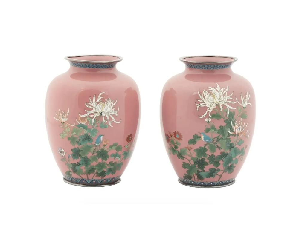 A nice pair of Japanese silver mounted vases enamel worked in silver wire decorated with polychrome chrysanthemums and birds on a pink ground. Features stylized geometric patterned bands to the short neck and bottom. Unmarked. Meiji era, 1868 to